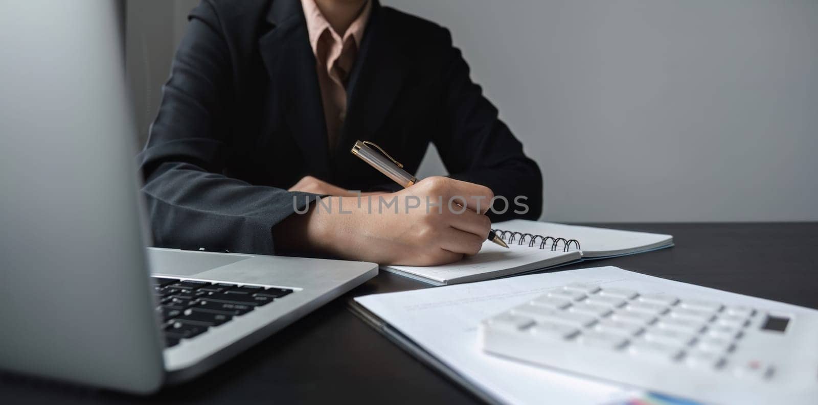 close up, Attractive young businesswoman working using laptop on corporate charts and graphs on wooden table in office room.