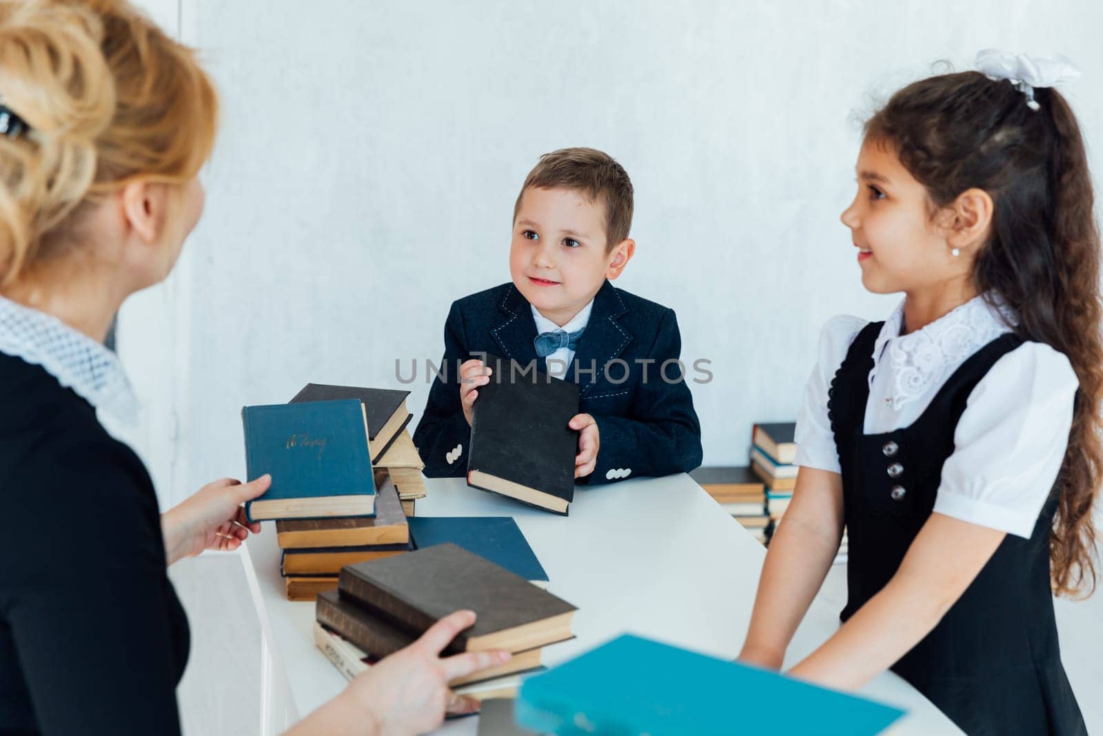 teacher at lesson at school with children and books