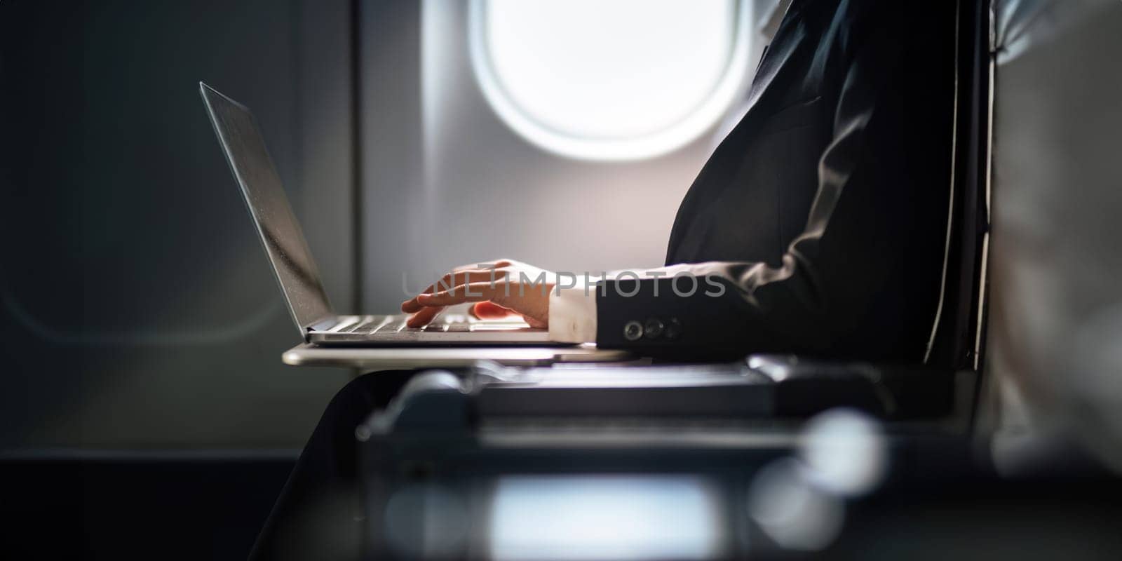 Successful Asian business woman, Business woman working in airplane cabin during flight on laptop computer by nateemee