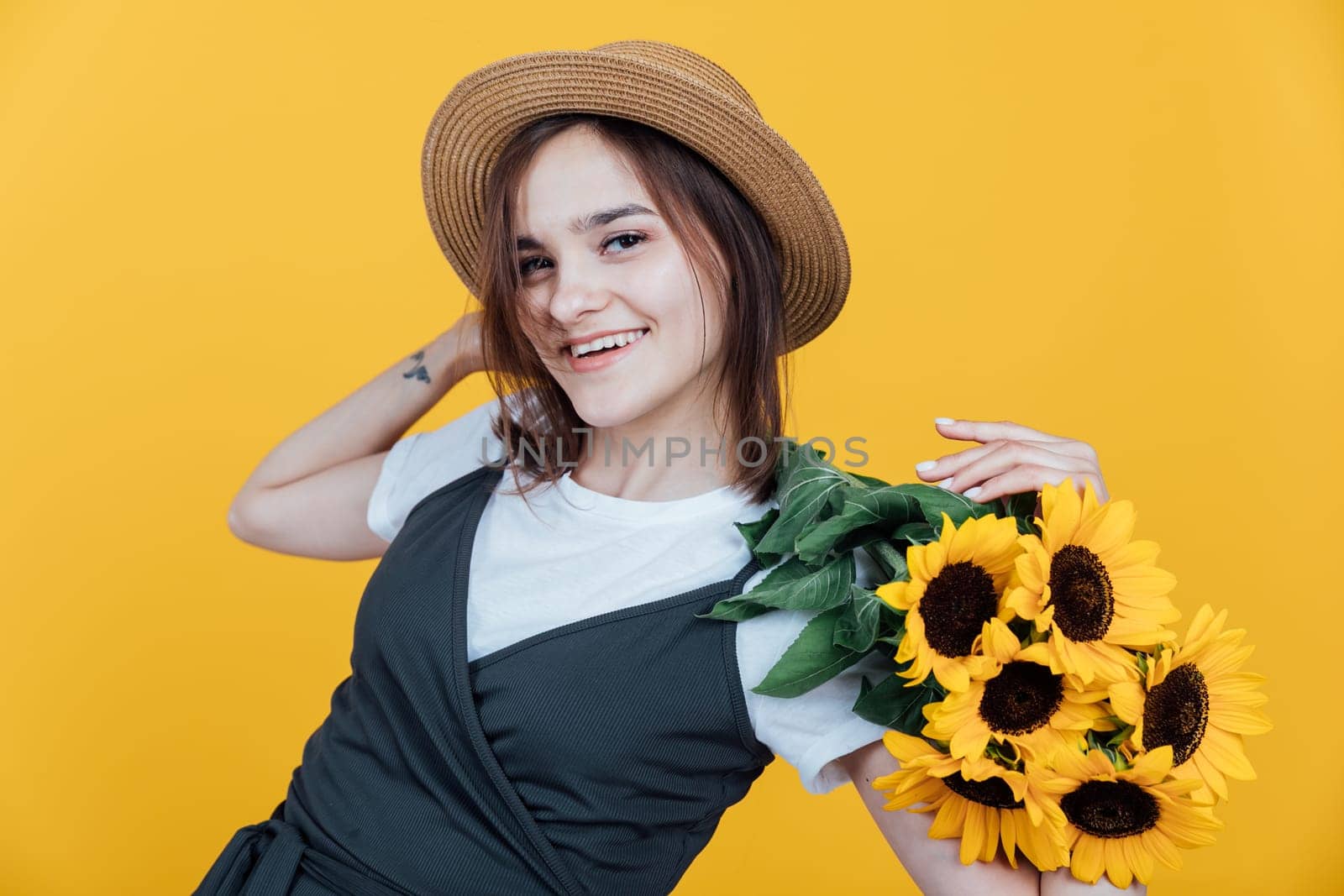 Woman in a hat with a bouquet of daisies on a yellow background by Simakov