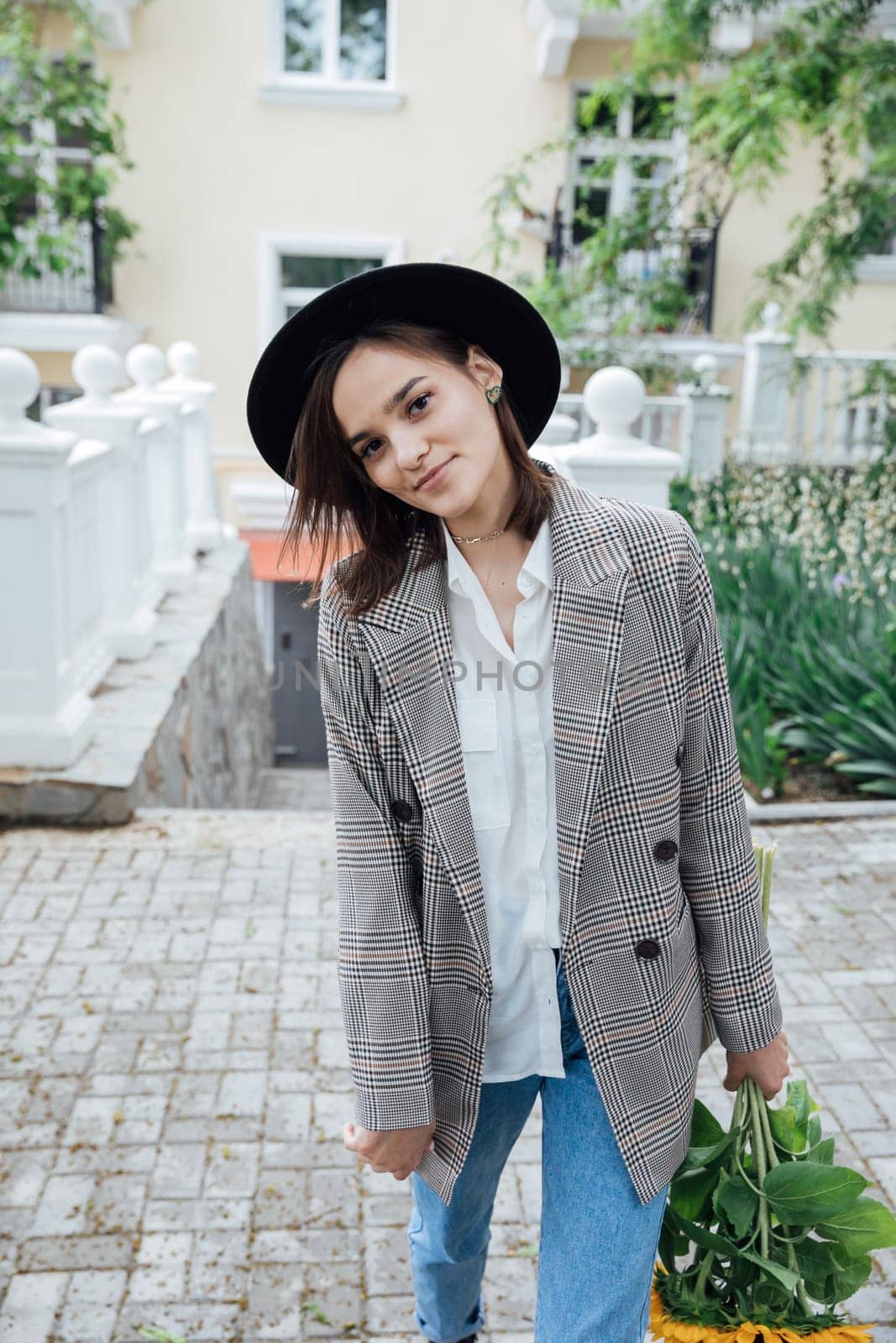 woman in a hat on a walk near the house