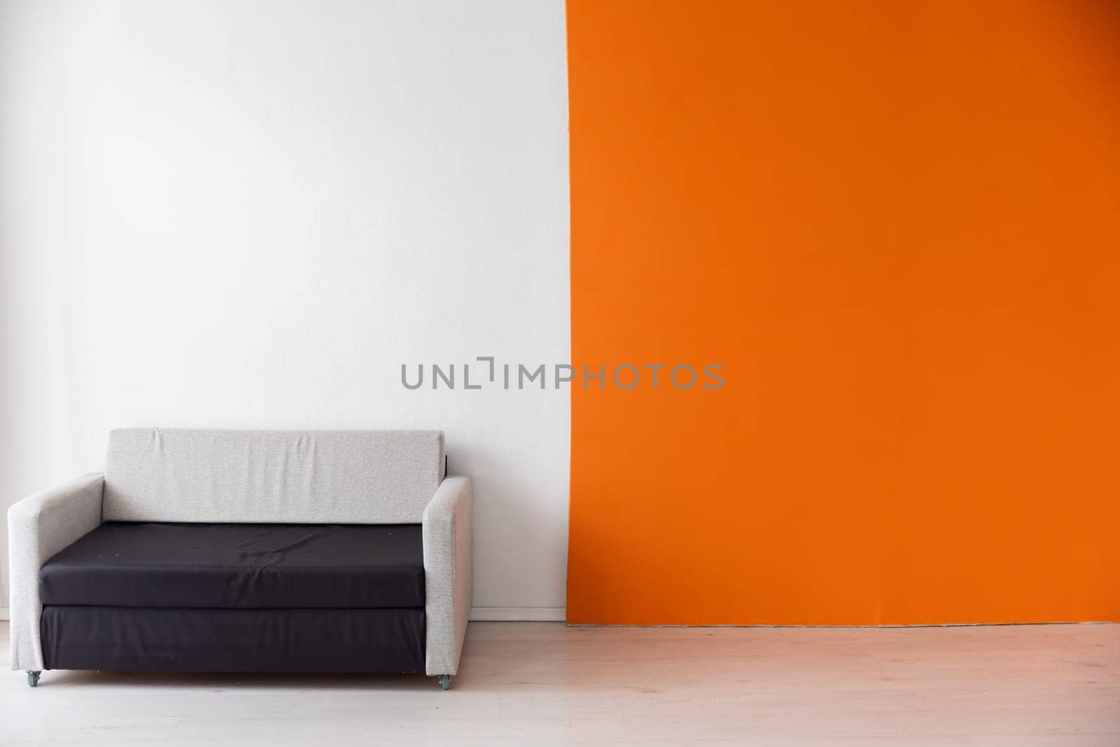 sofa near the white orange wall in a room