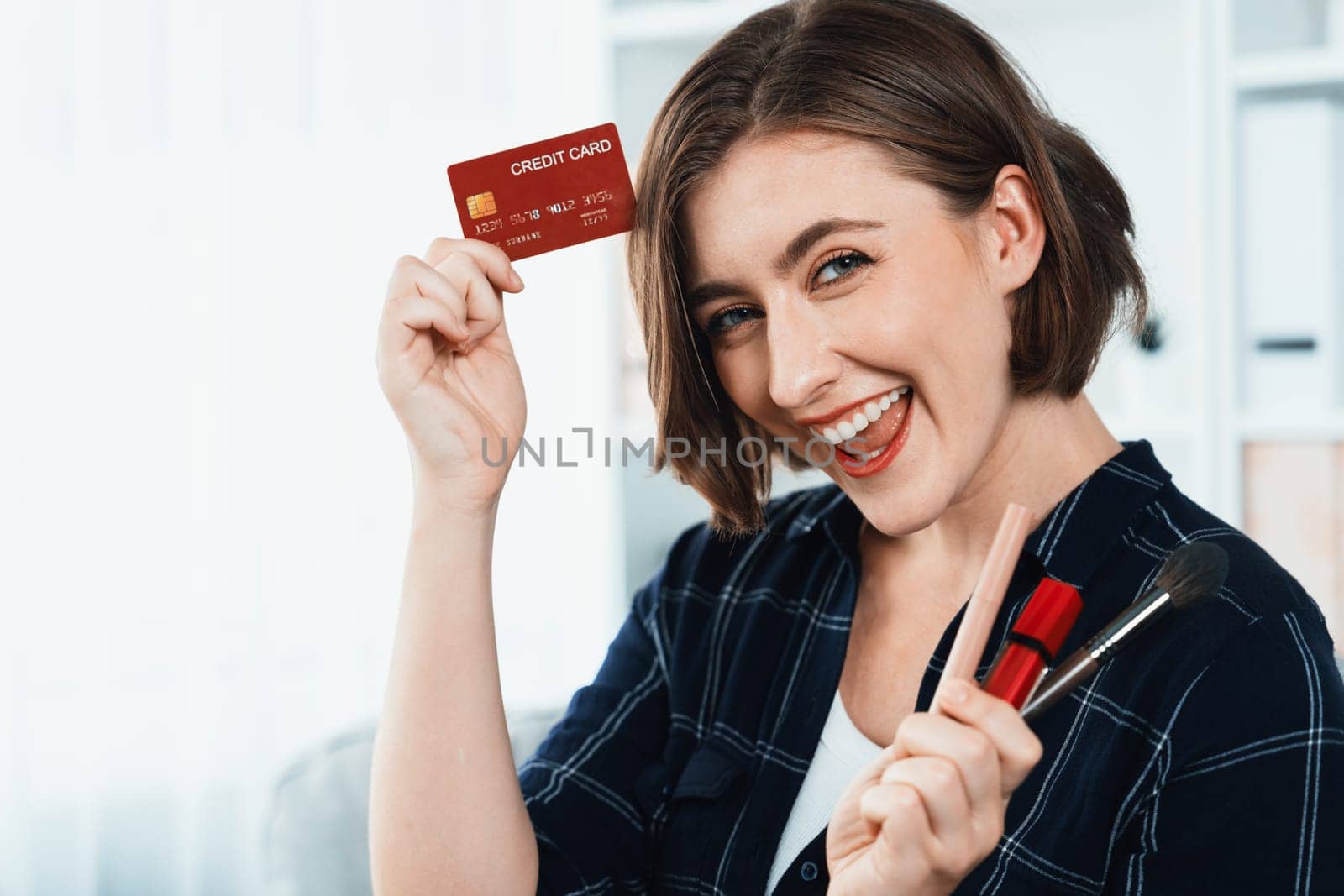 Young happy woman buy product by online shopping at home while ordering items from the internet with credit card online payment system protected by utmost cyber security from online store platform