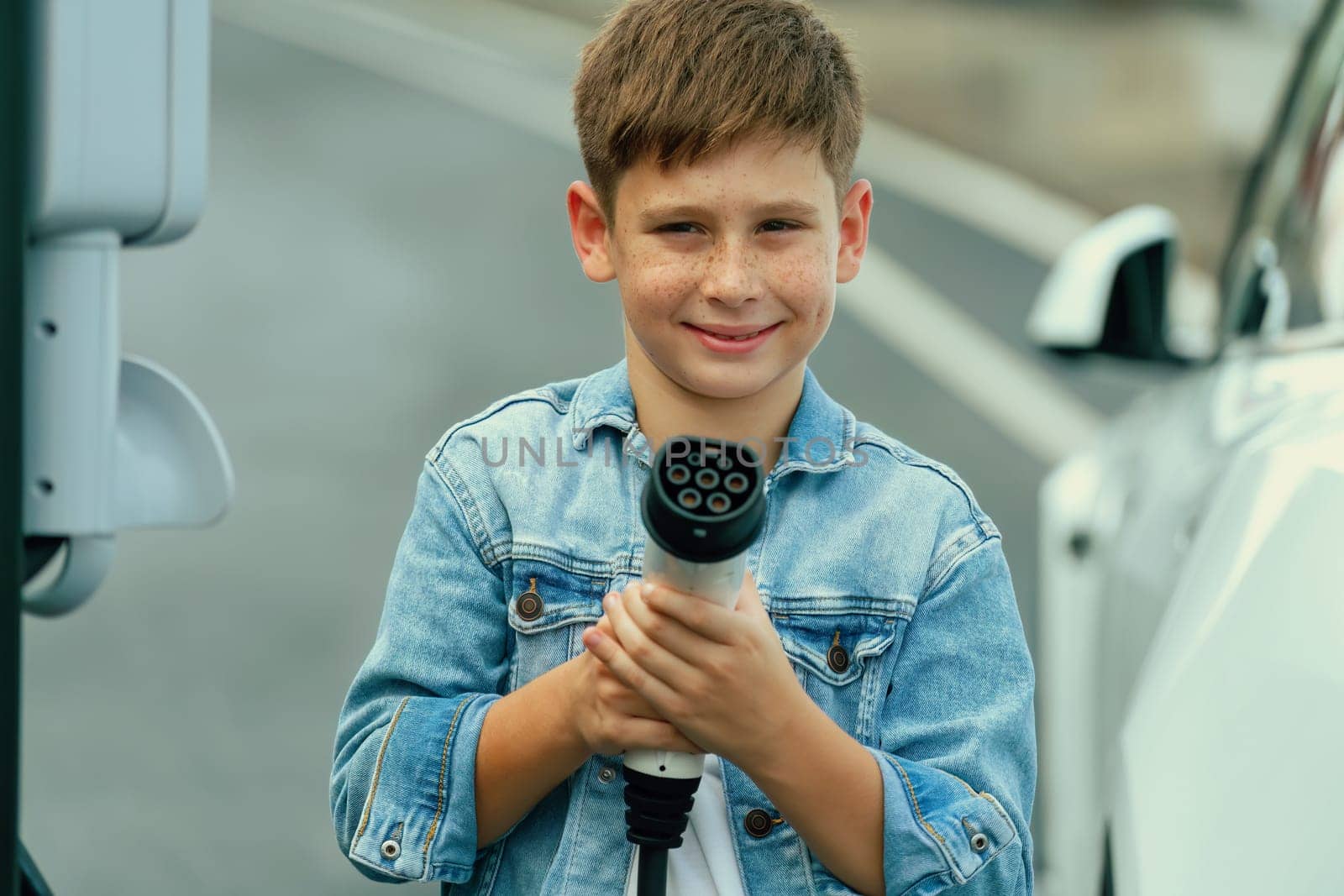 Road trip vacation with eco-friendly EV car and little boy pointing. Perpetual by biancoblue