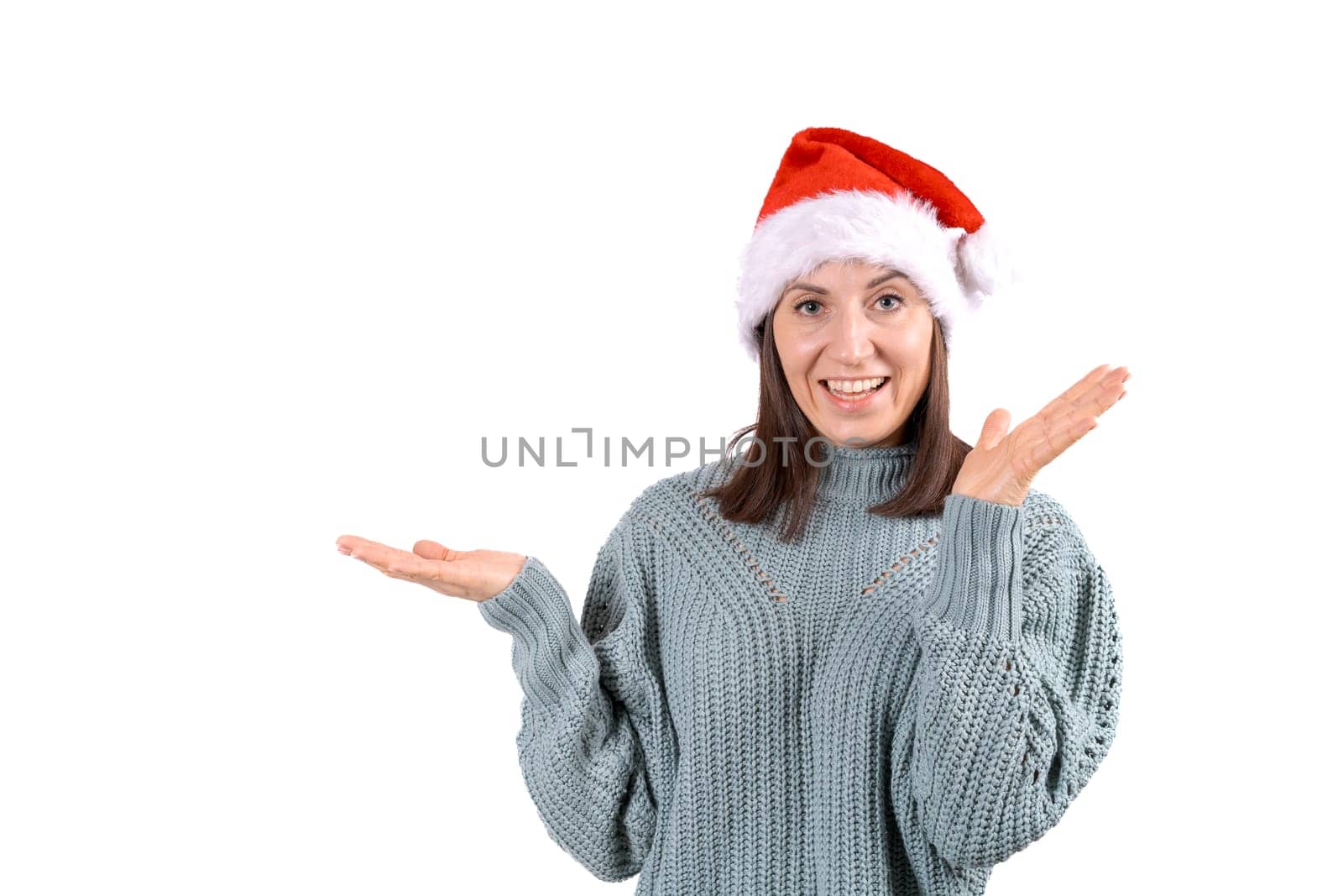 Happy woman in red santa claus hat shows with hands to the side Copy Space