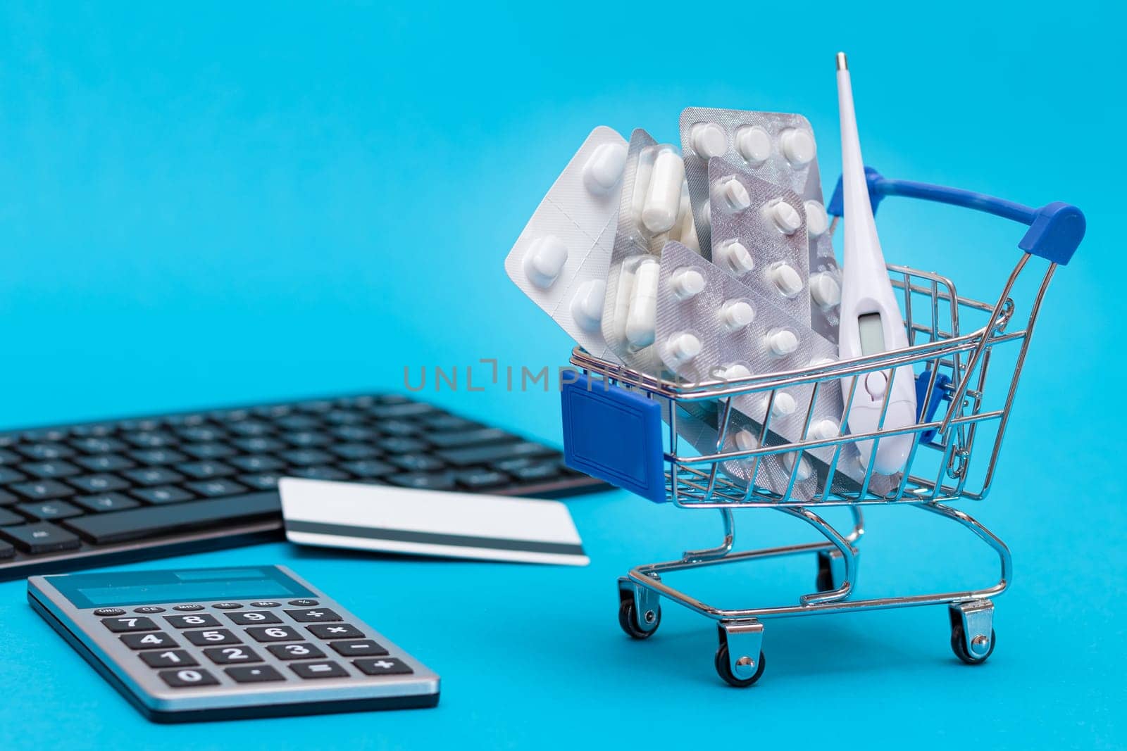 Ordering Medicines. Expensive Medicine and Inflation Concept: Pills and Capsules in a Shopping Cart on Blue Background. Global Pharmaceutical Industry and Big Pharma. Trade in Medicines