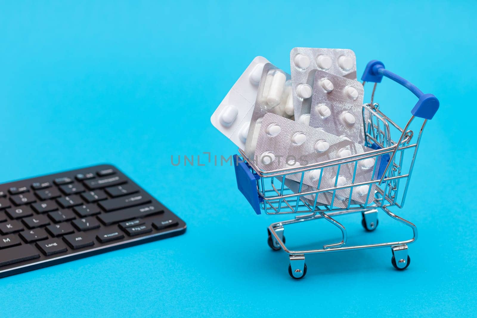 Ordering Medicines. Expensive Medicine and Inflation Concept: Pills and Capsules in a Shopping Cart on Blue Background. Global Pharmaceutical Industry and Big Pharma. Trade in Medicines