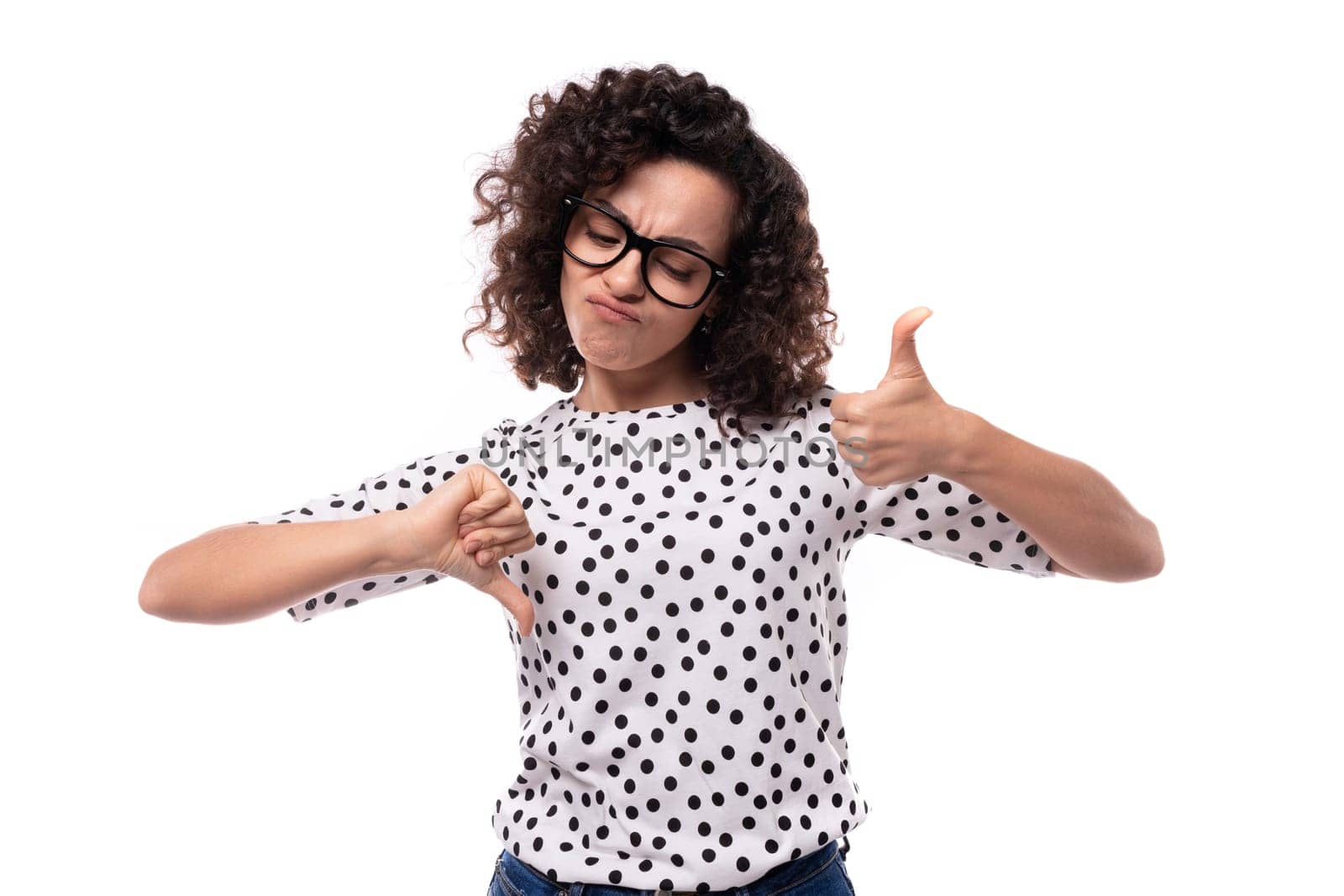 young authentic curly brunette slim lady wearing polka dot short sleeve shirt on white background.