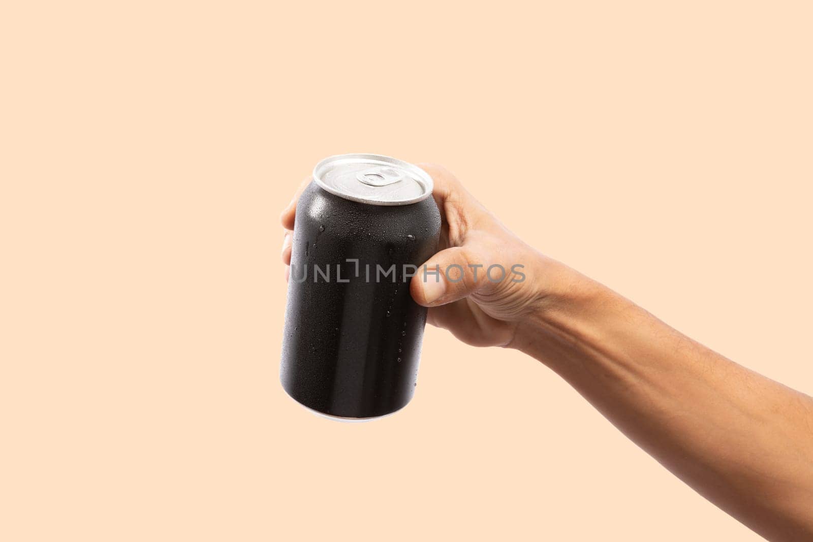 Close-up of hand holding Empty aluminum can with condensation. isolated on green Background. front view.