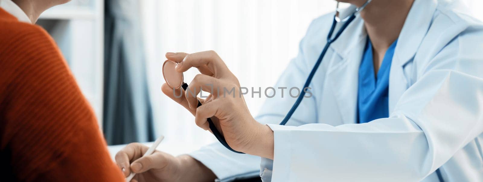 Patient attend doctor's appointment at clinic or hospital office. Doctor examining and diagnosis symptoms while checking the patient's pulse with stethoscope. Panorama Rigid