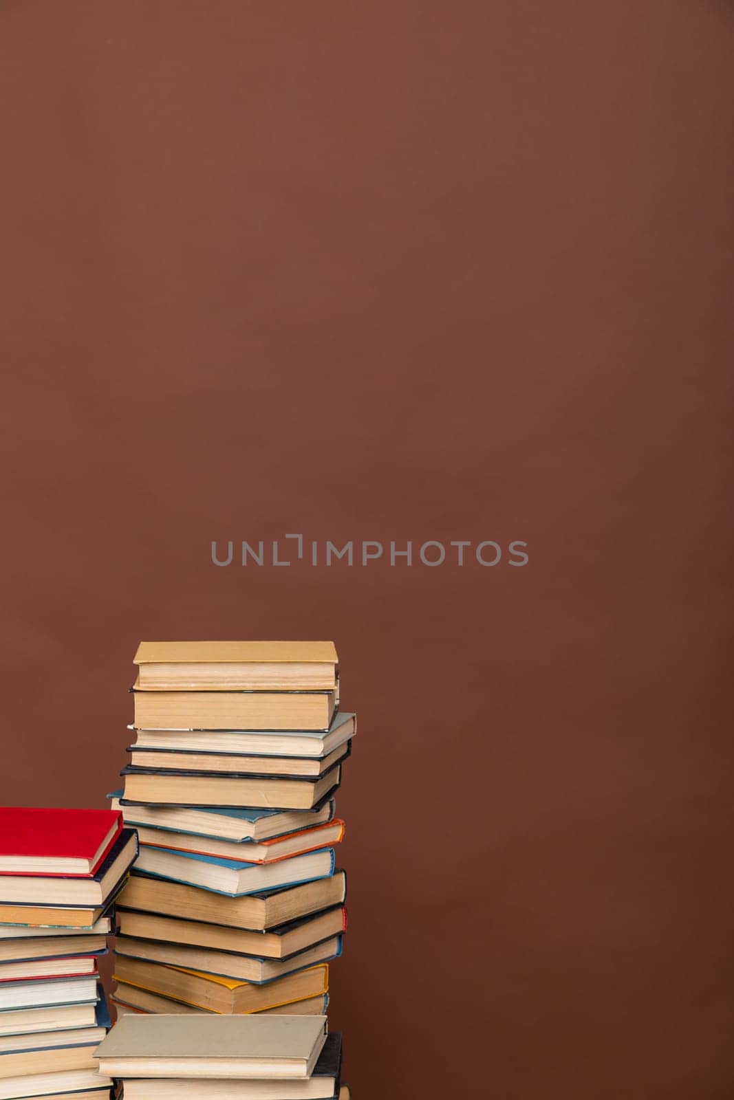 stack of books on brown background library education by Simakov