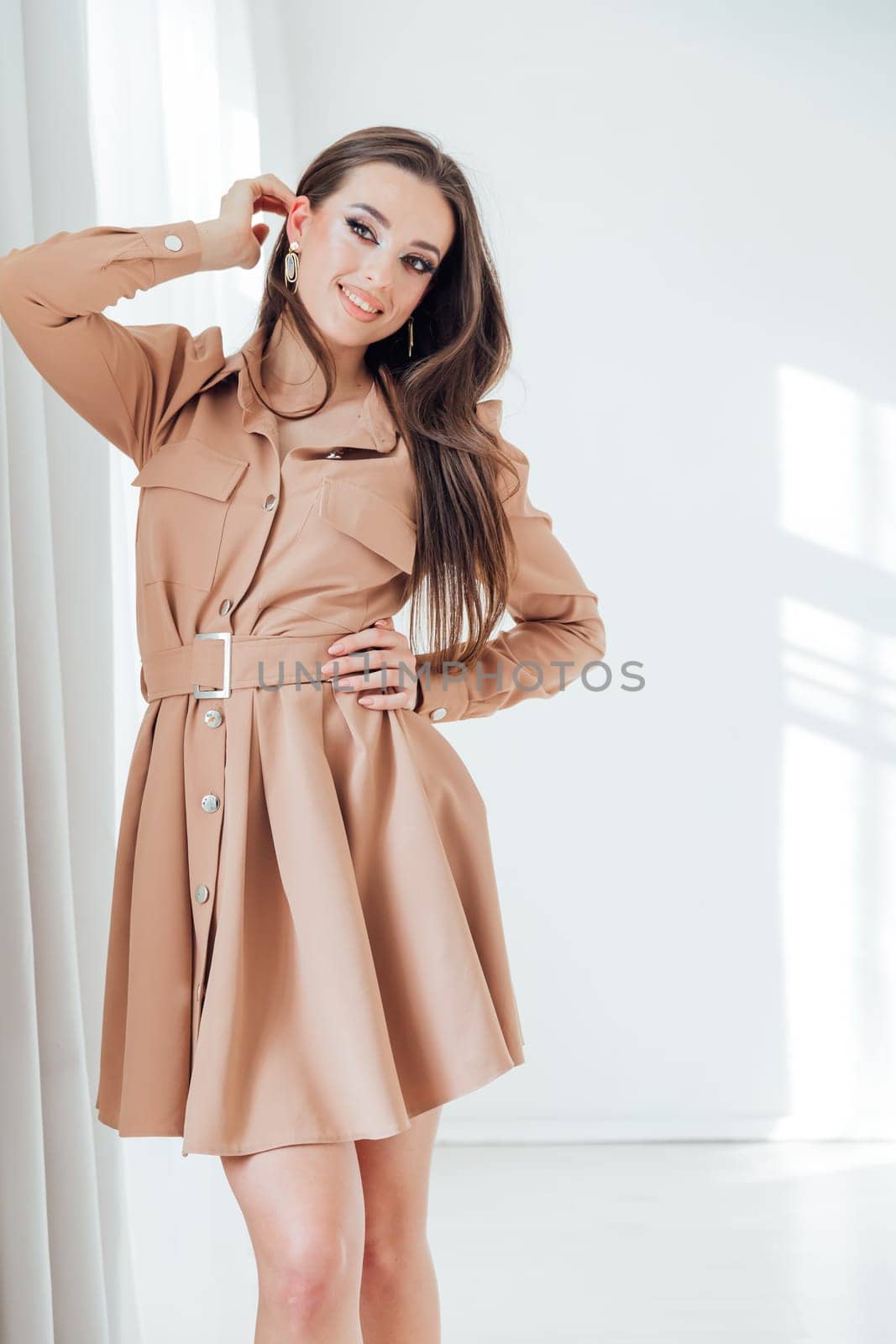Beautiful woman in dress posing in bright room by Simakov