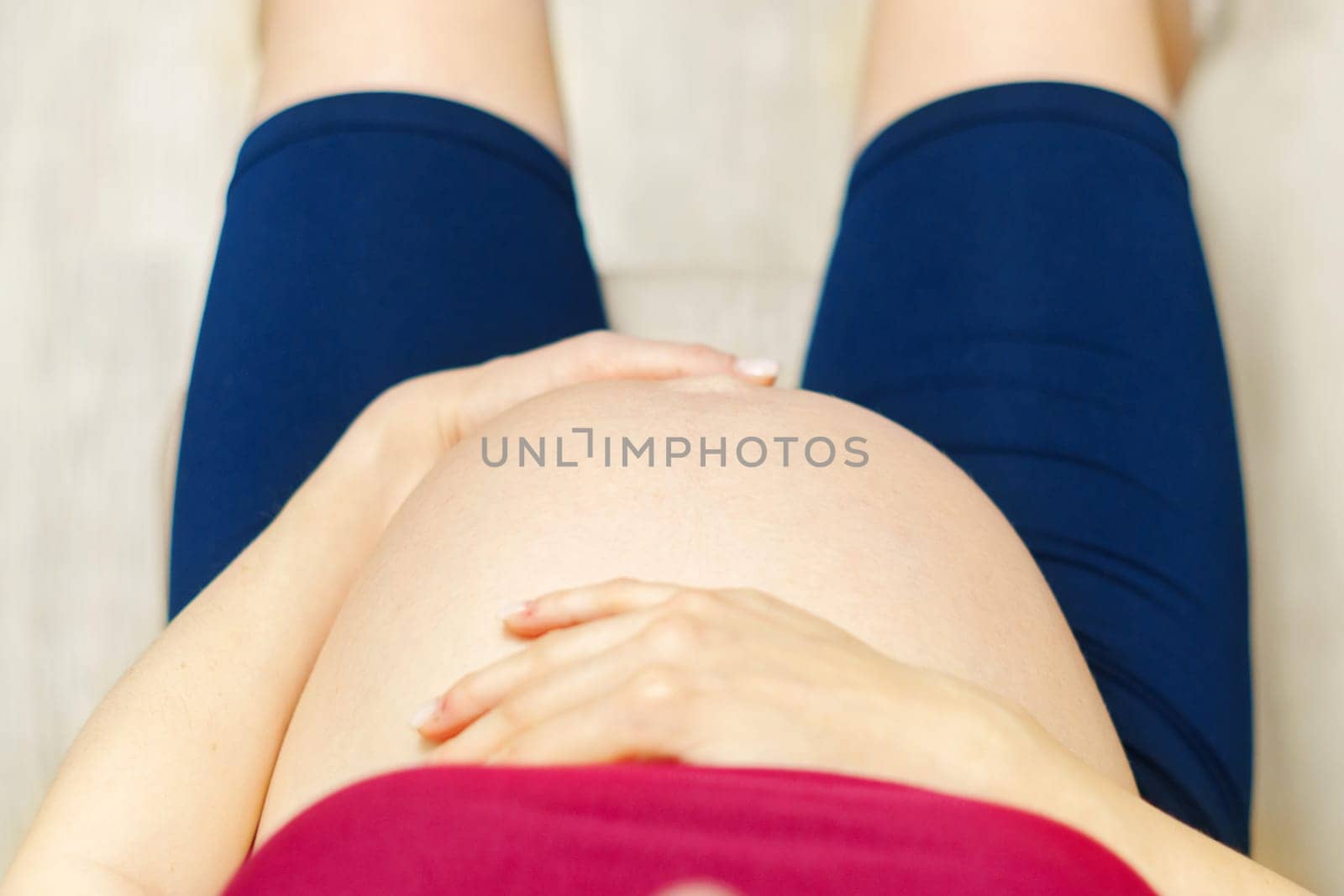 Close-up of pregnant woman belly in third trimester. Baby expectation. Love, happiness and safety concept.
