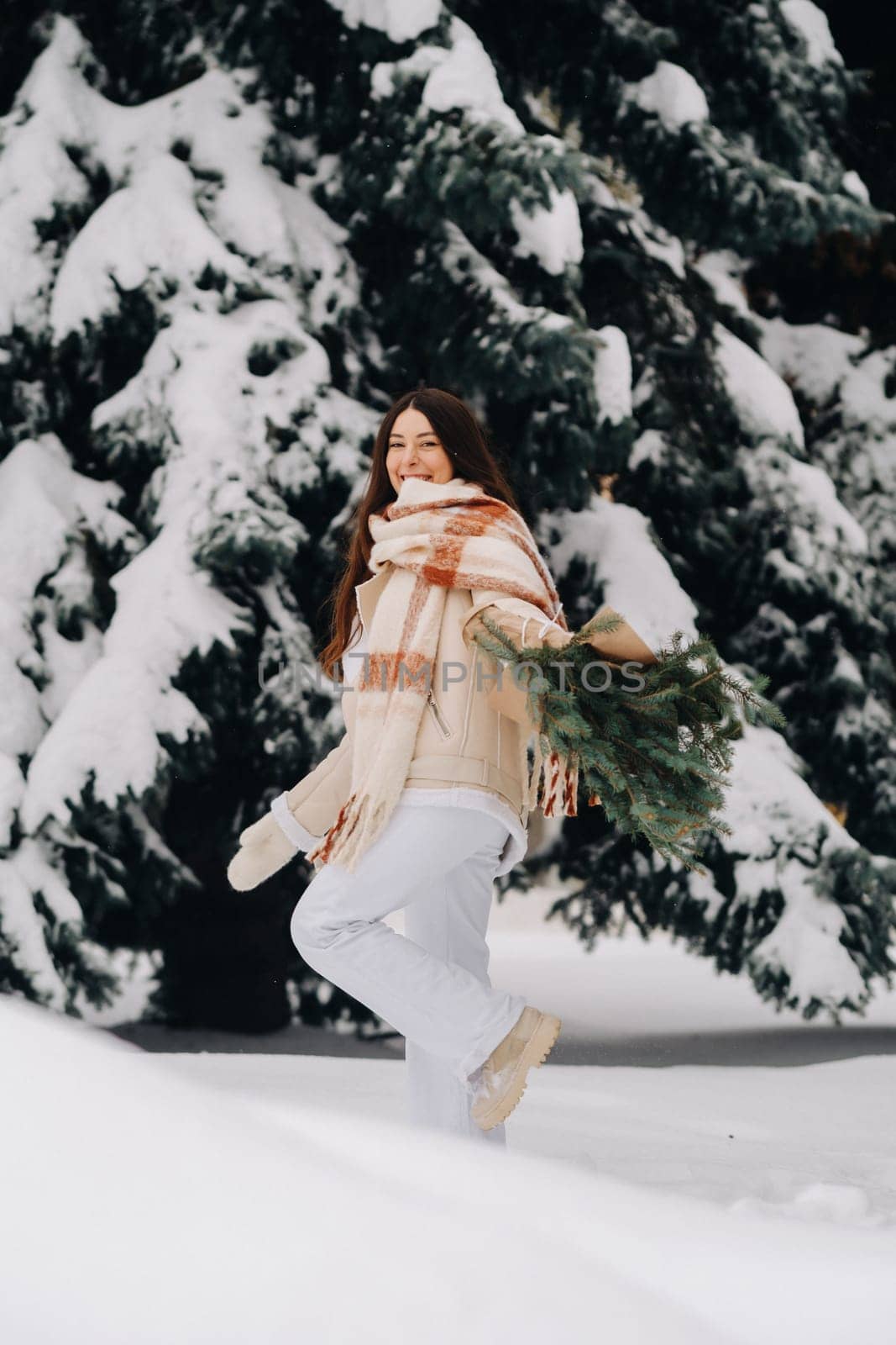 A girl in a winter forest with a bouquet of fir branches. Snowy winter by Lobachad