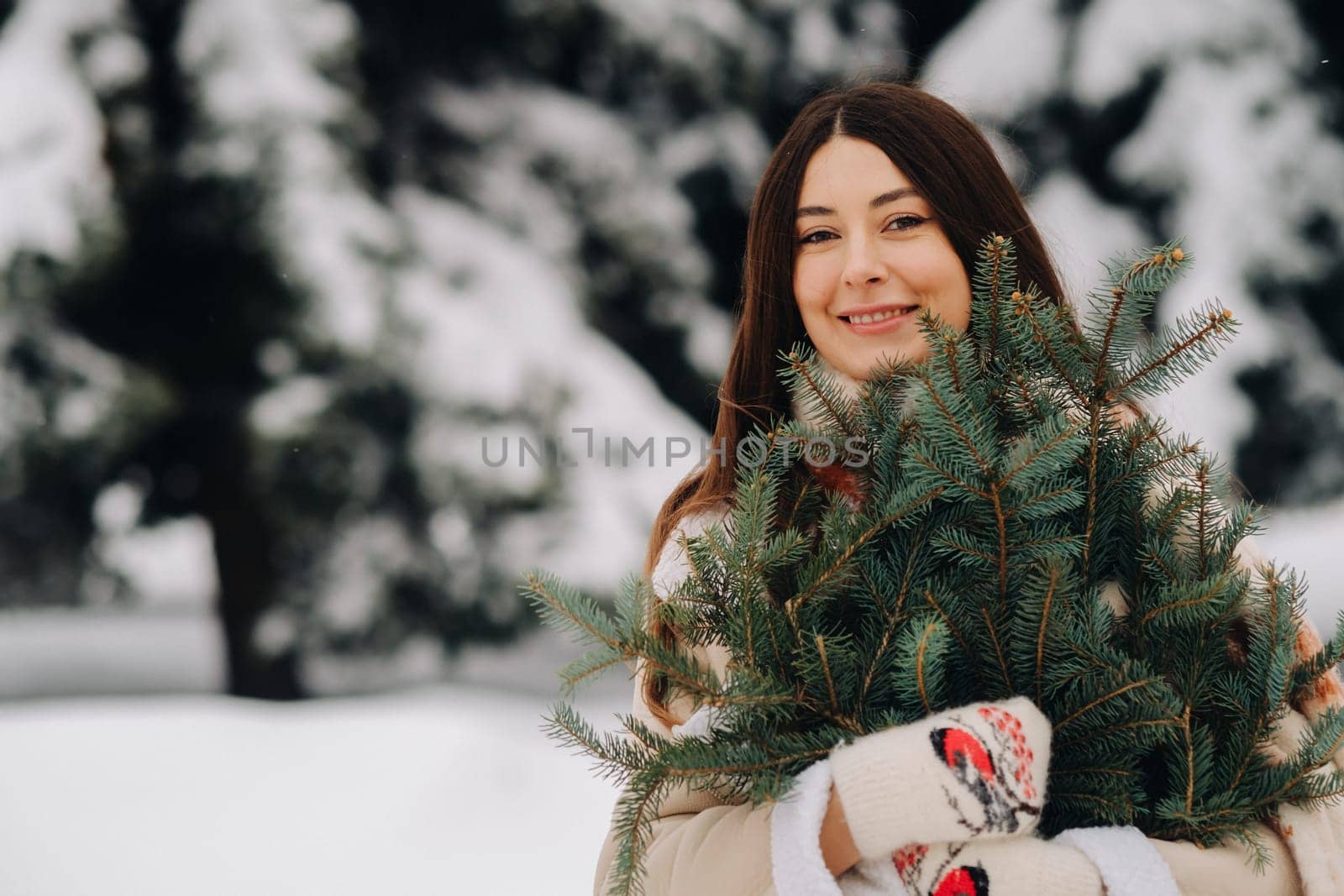 A girl in a winter forest with a bouquet of fir branches. Snowy winter by Lobachad