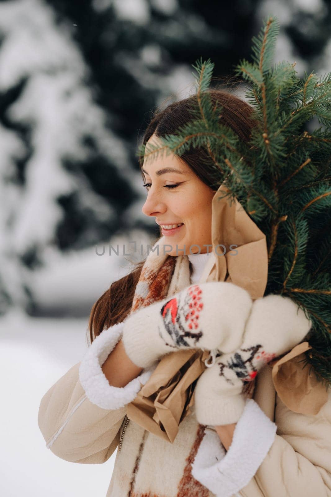 A girl in a winter forest with a bouquet of fir branches. Snowy winter.