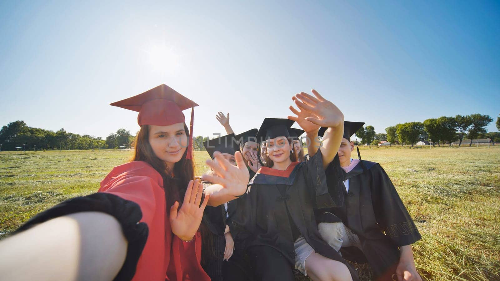 College alumni take selfies in the meadow. by DovidPro