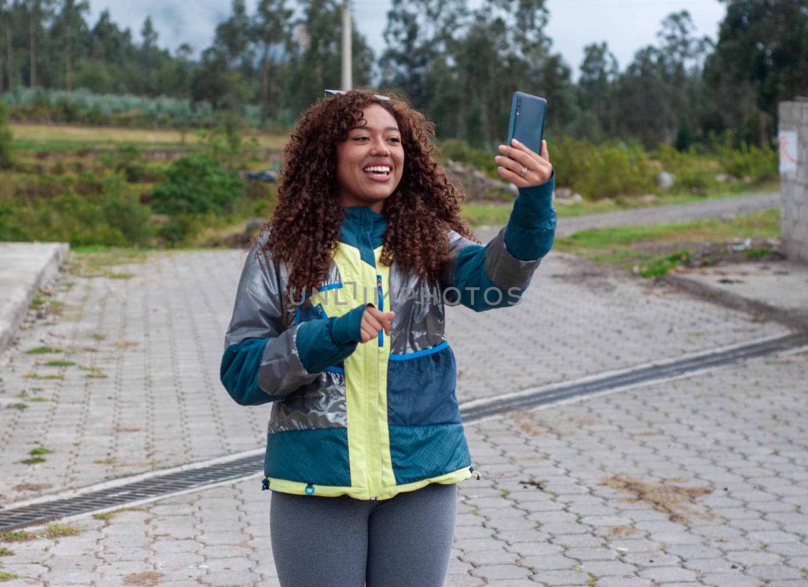 smiling girl with her smart phone creating content for her social networks in a rural setting. High quality photo