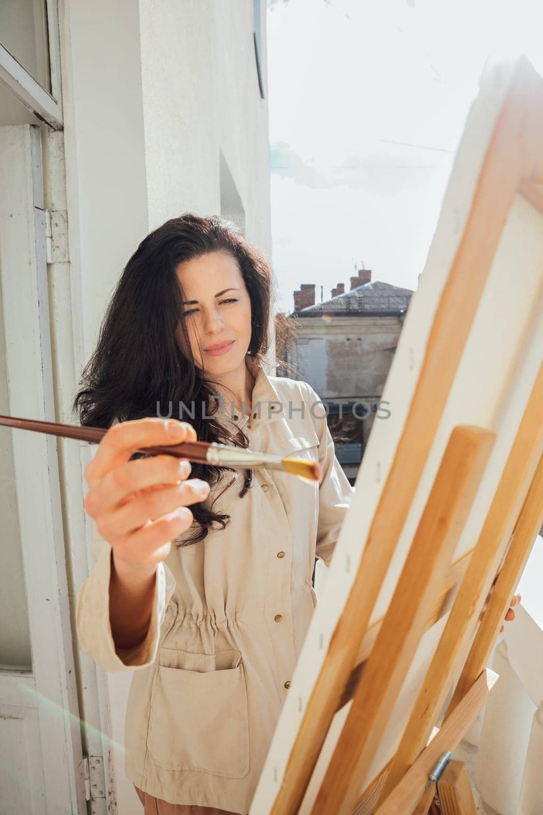 A woman artist at an easel in an art studio paints a picture by Simakov
