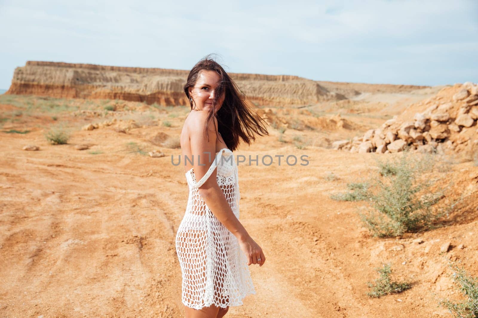 Woman in mesh clothes in the desert on a walk in a sand quarry