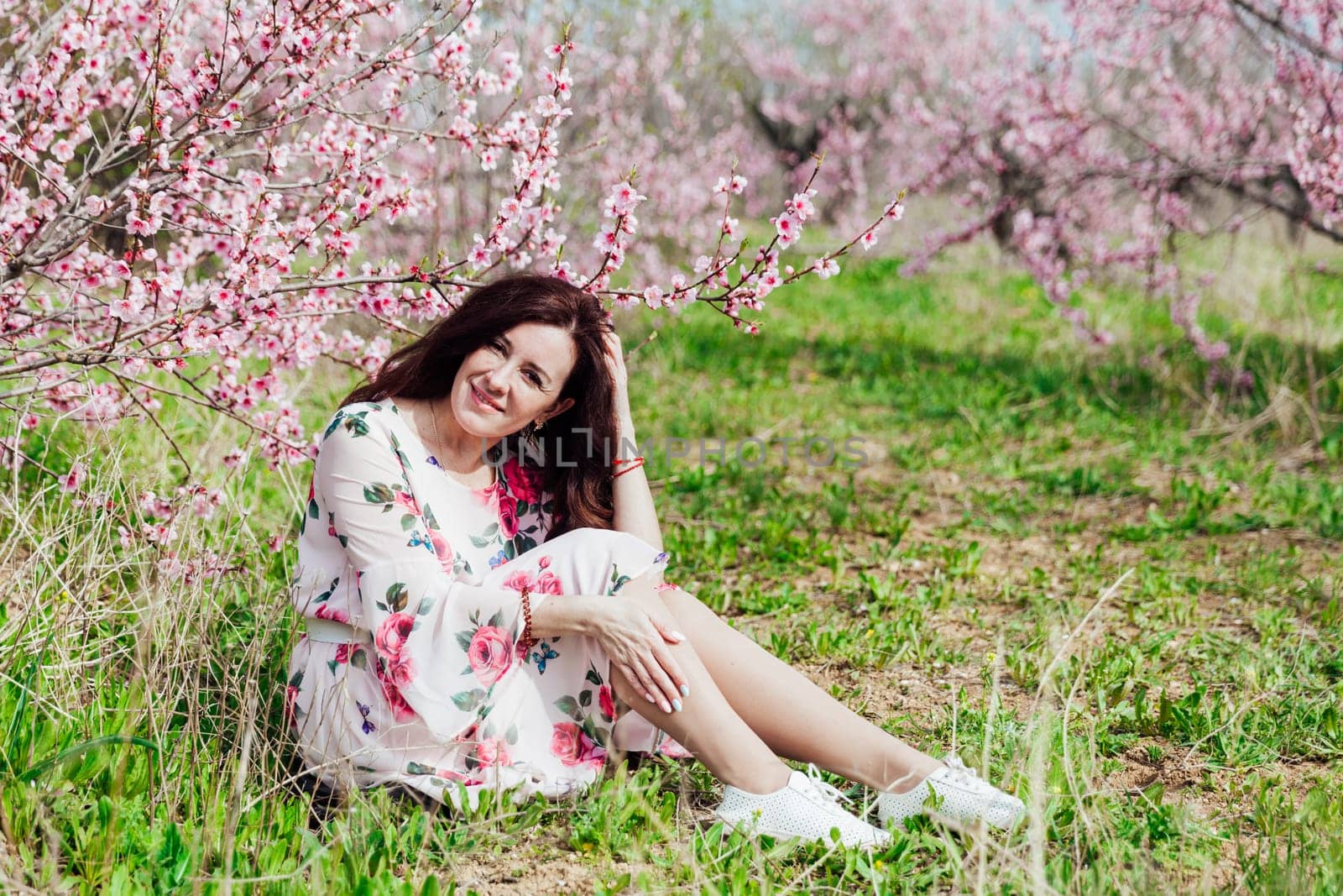 travel walk beautiful brunette woman in flowering trees spring nature by Simakov