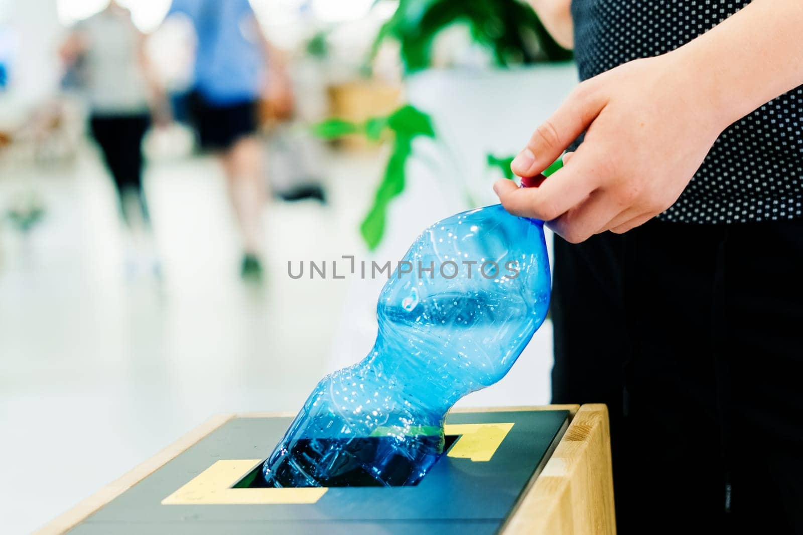 Selective focus close up hand throwing empty plastic bottle in the recycling garbage trash or bin