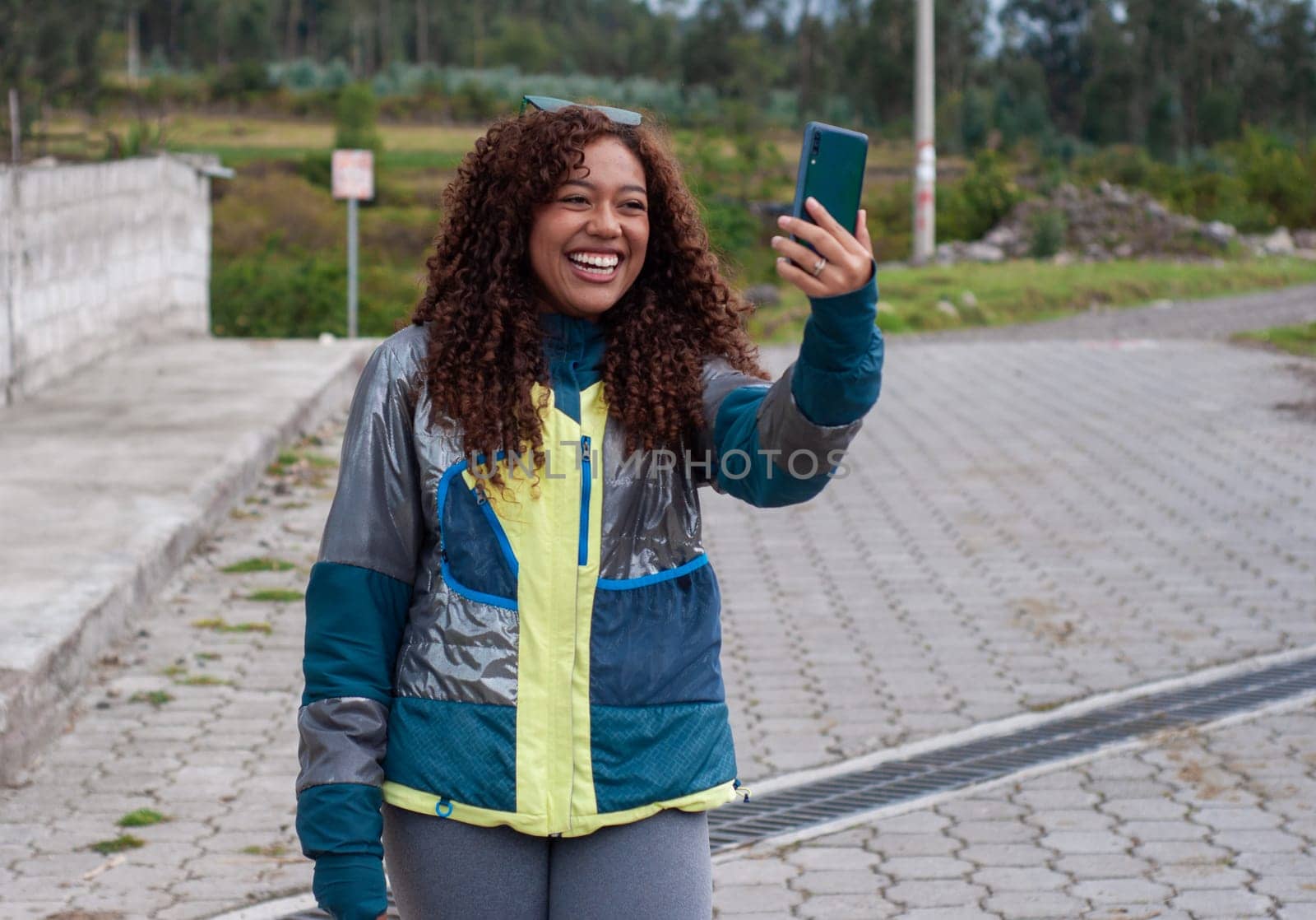 latina influencer making content on social media for her audience on a tourist trip with a big smile. High quality photo