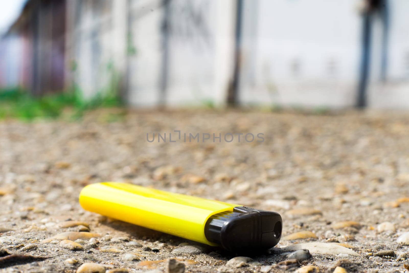 A match, a hand with a matches against the background of old garages in city. by Zelenin