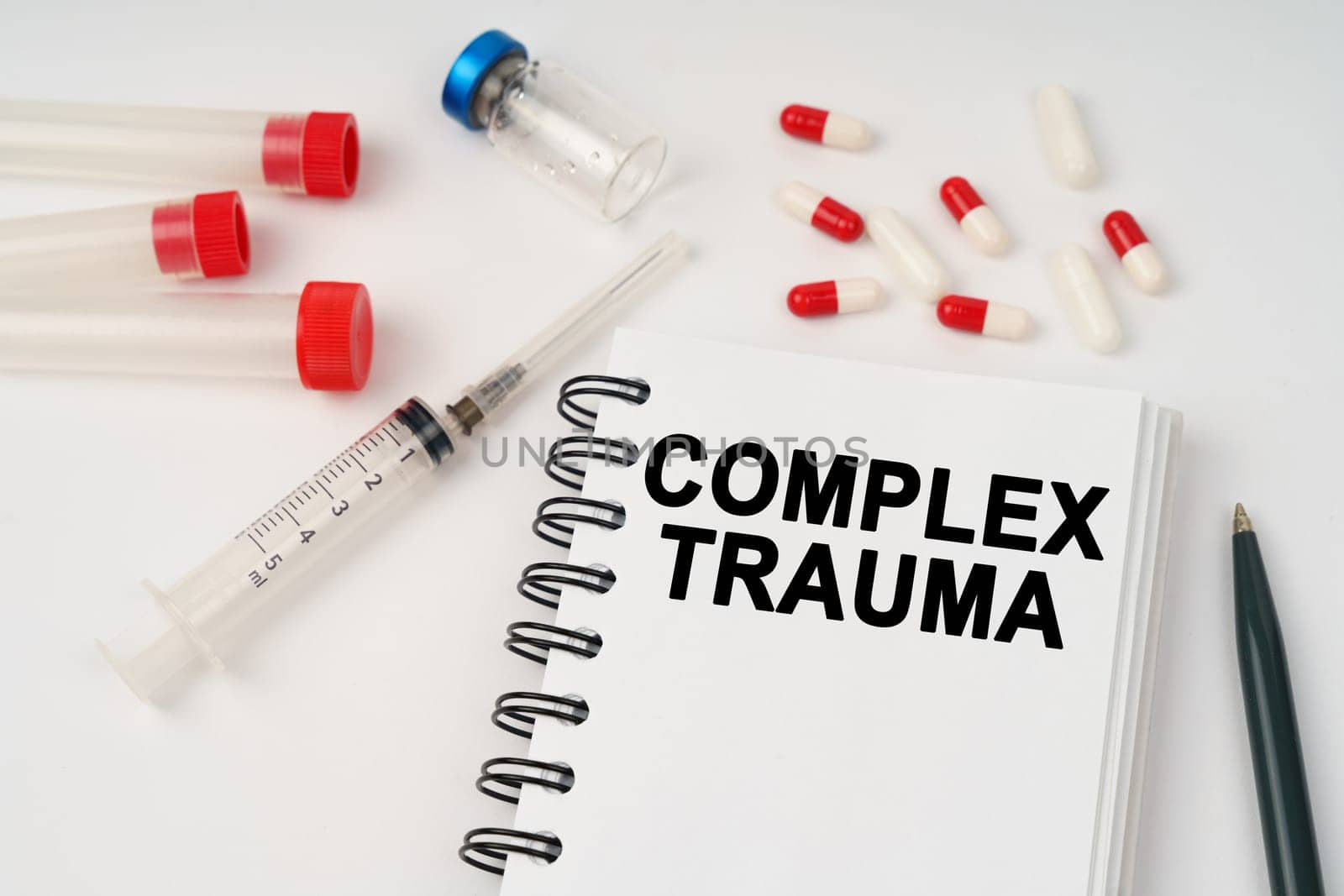 Medical concept. On the table are pills, injections, a syringe and a notepad with the inscription - complex trauma