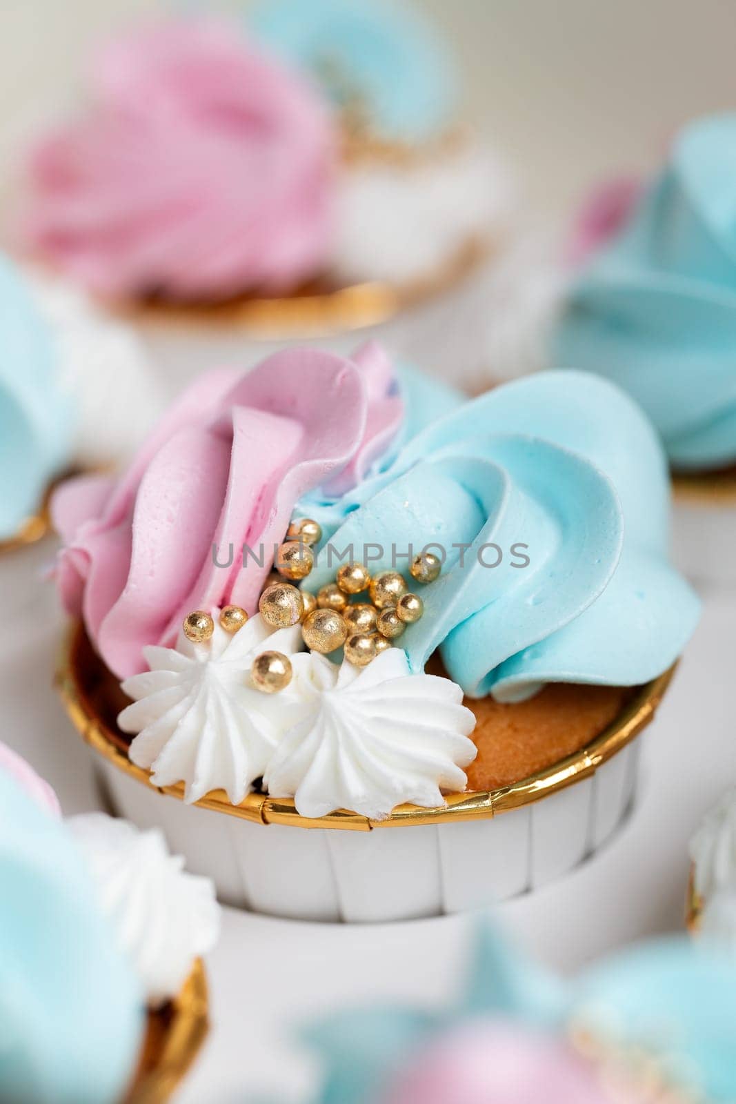 Cupcake blue and pink for gender party. boy or girl. delicious cupcakes with blue and pink cream, golden sparkles celebration concept when the gender of the child becomes known. Festive baby shower sweets concept close up