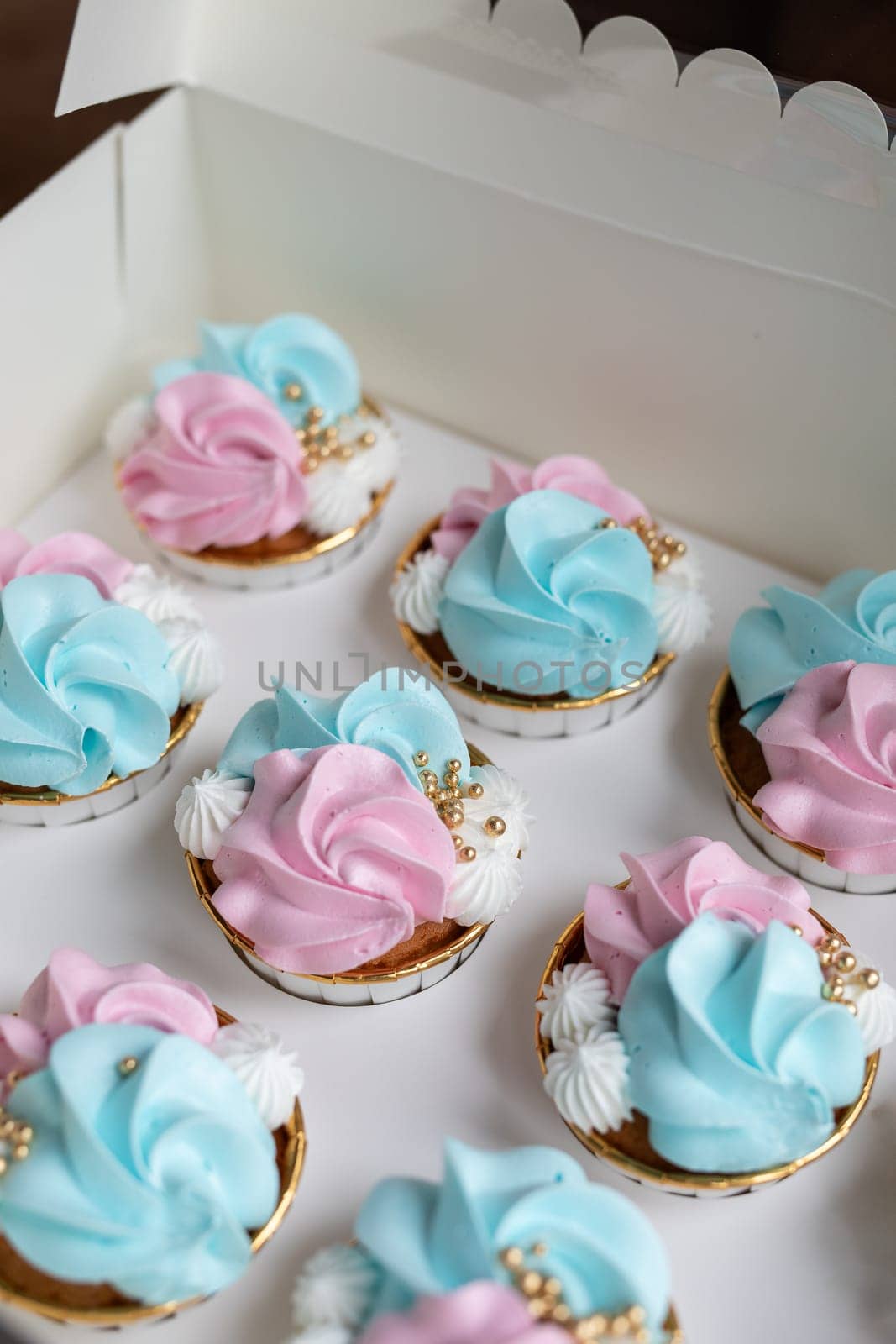 Cupcake blue and pink for gender party. boy or girl. delicious cupcakes with blue and pink cream, golden sparkles celebration concept when the gender of the child becomes known. Festive baby shower sweets concept by Annebel146