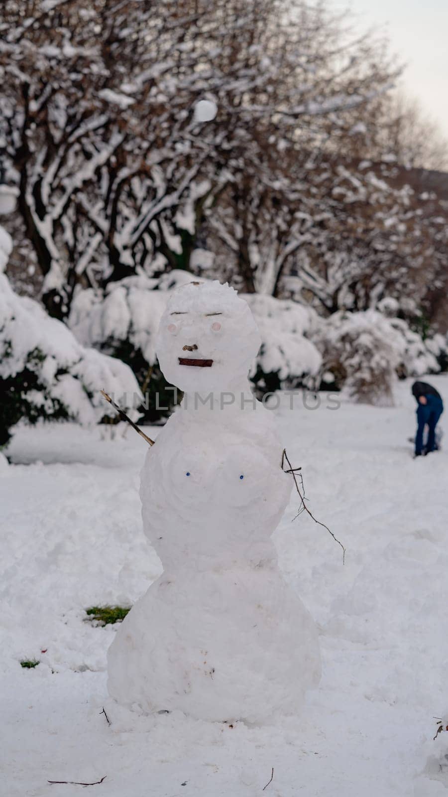 Snowman in a winter city park. Snowman made by children in a park by vladispas
