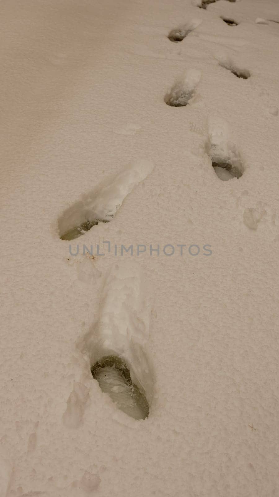 Foot traks in the snow, street covered with snow. by vladispas