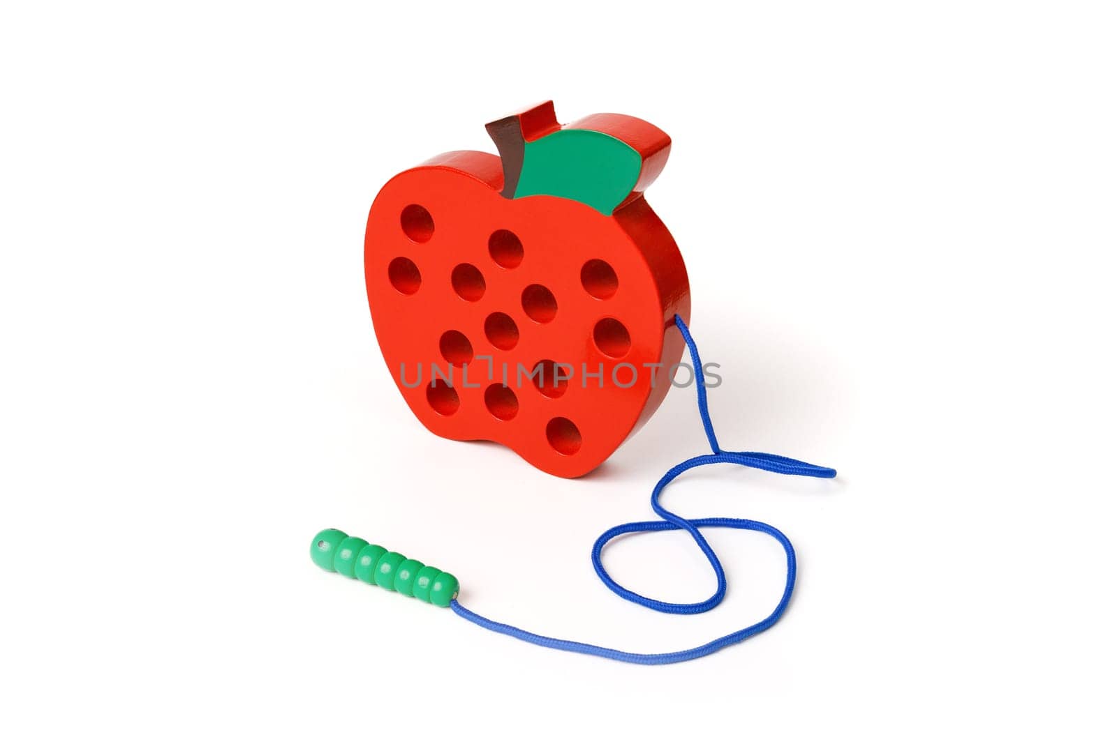 Children's wooden toy in the shape of a red apple with a worm on a rope isolated on white background.