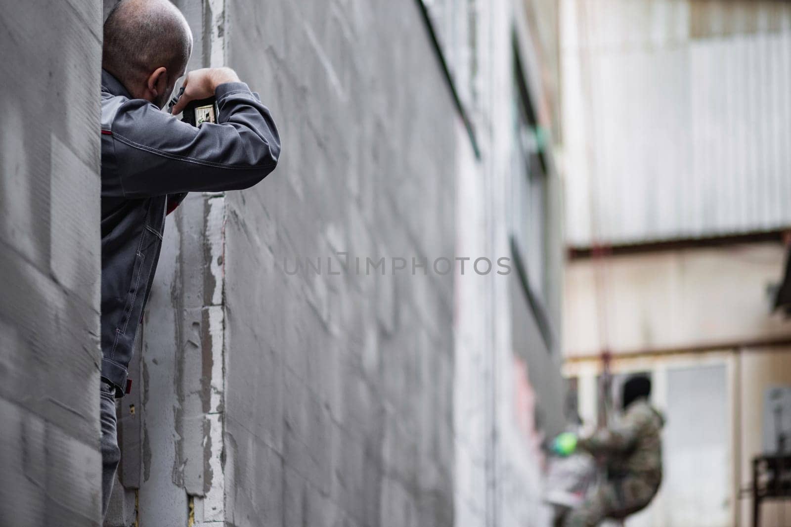 A professional industrial photographer supervises and records construction stages at a construction site.