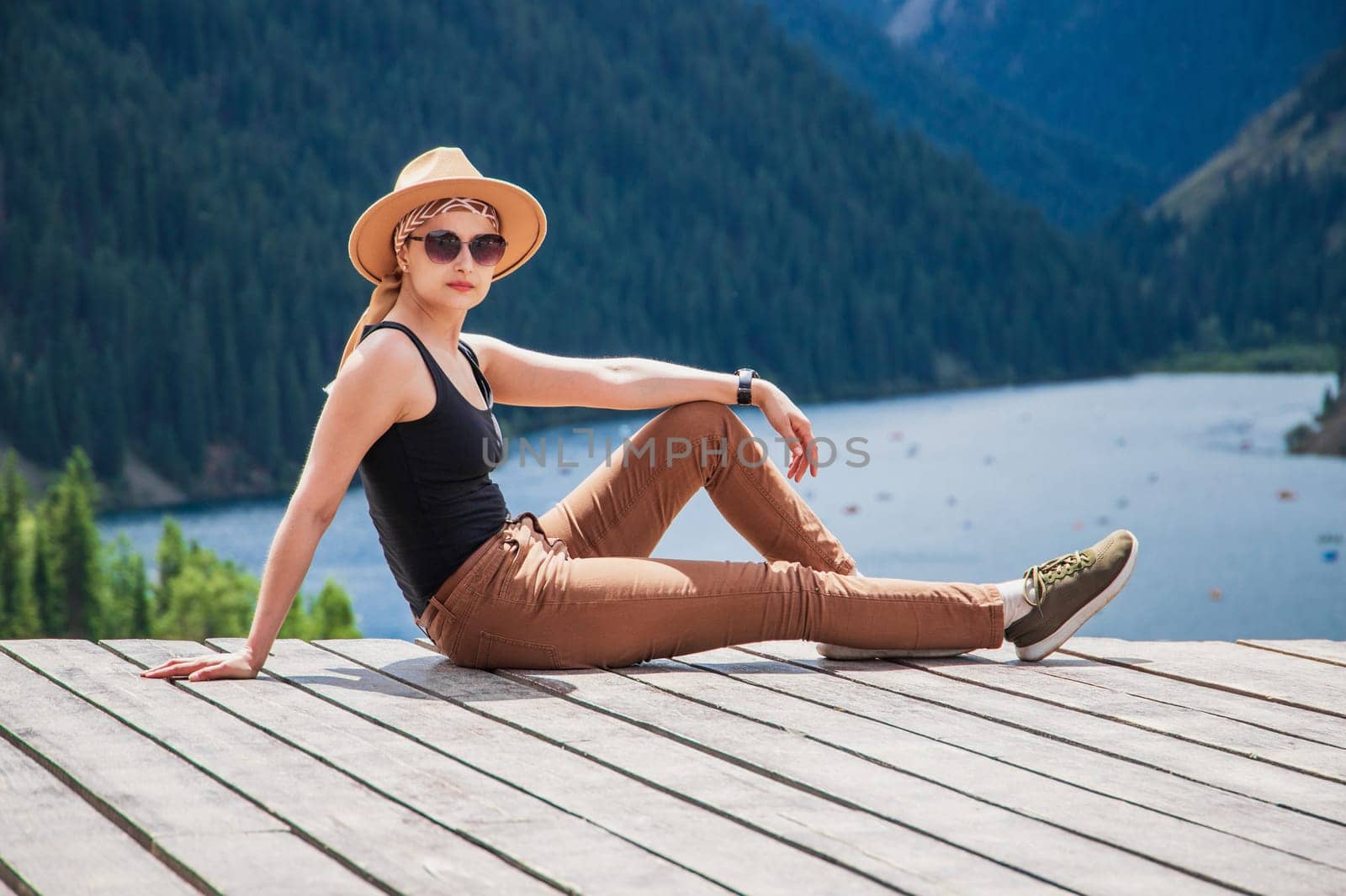A young woman in safari style went out to nature outside the city, taking a weekend tour to the Kolsai mountain lake in the Tien Shan mountains by Rom4ek