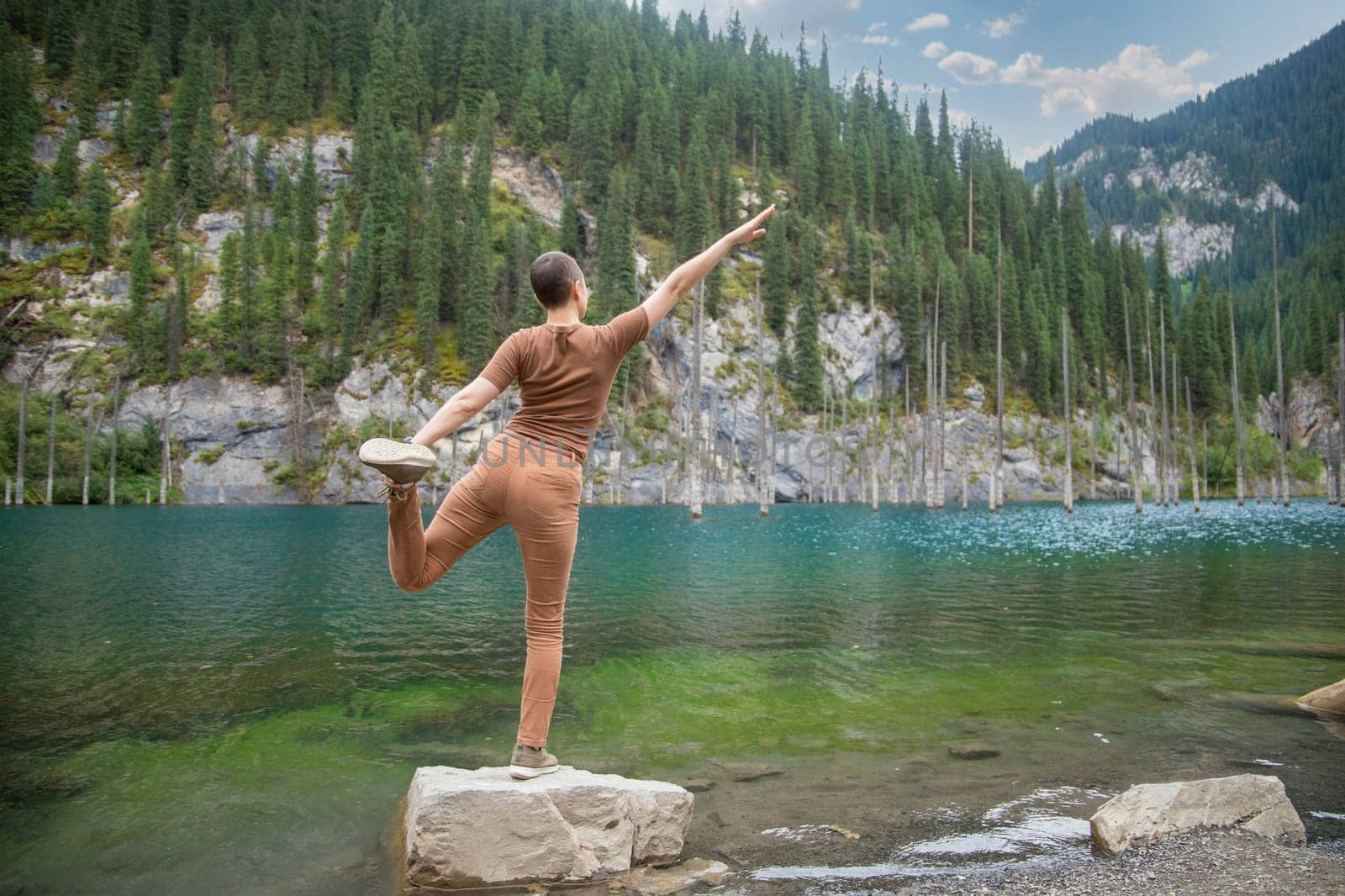 Woman retreat on Kaindy lake. Picturesque nature of Kazakhstan in Almaty region.