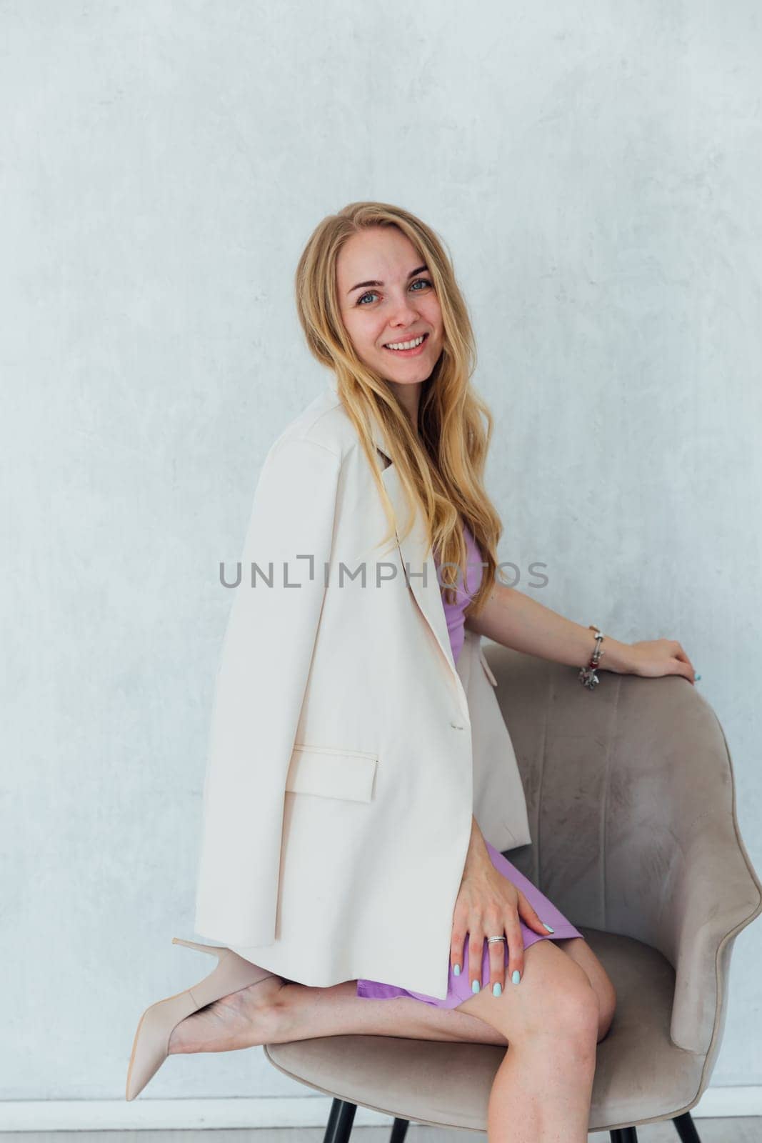 Portrait of beautiful blonde woman in dress and jacket