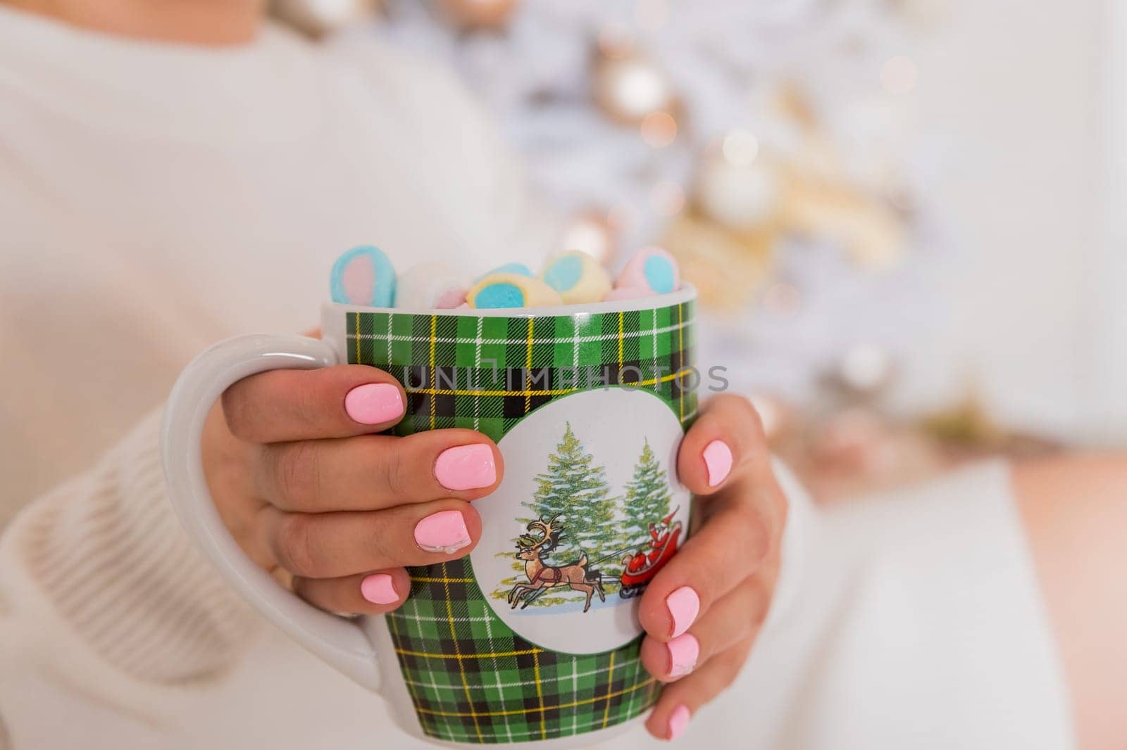 Close-up image, A tasty hot melted chocolate with tiny marshmallows cup in a woman's hand. Winter drinks concept