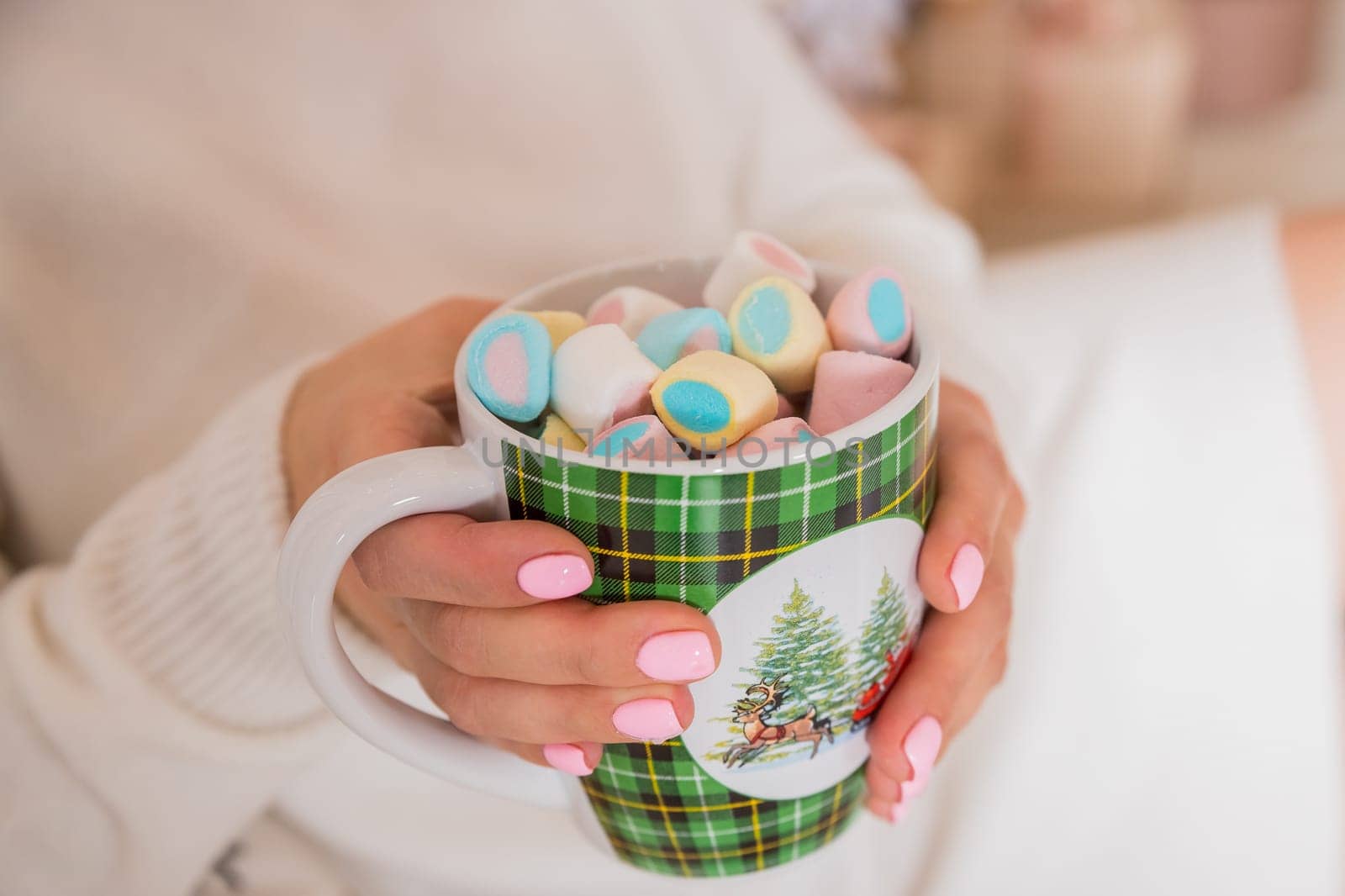 Close-up image, A tasty hot melted chocolate with tiny marshmallows cup in a woman's hand. Winter drinks concept