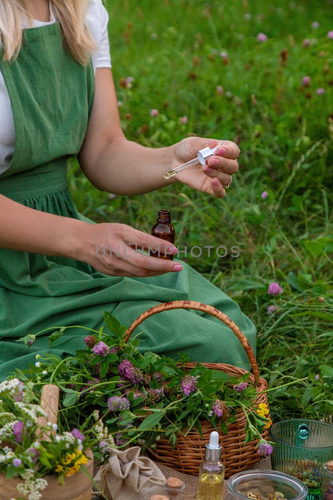 A woman makes herbal tincture. Selective focus. Nature.