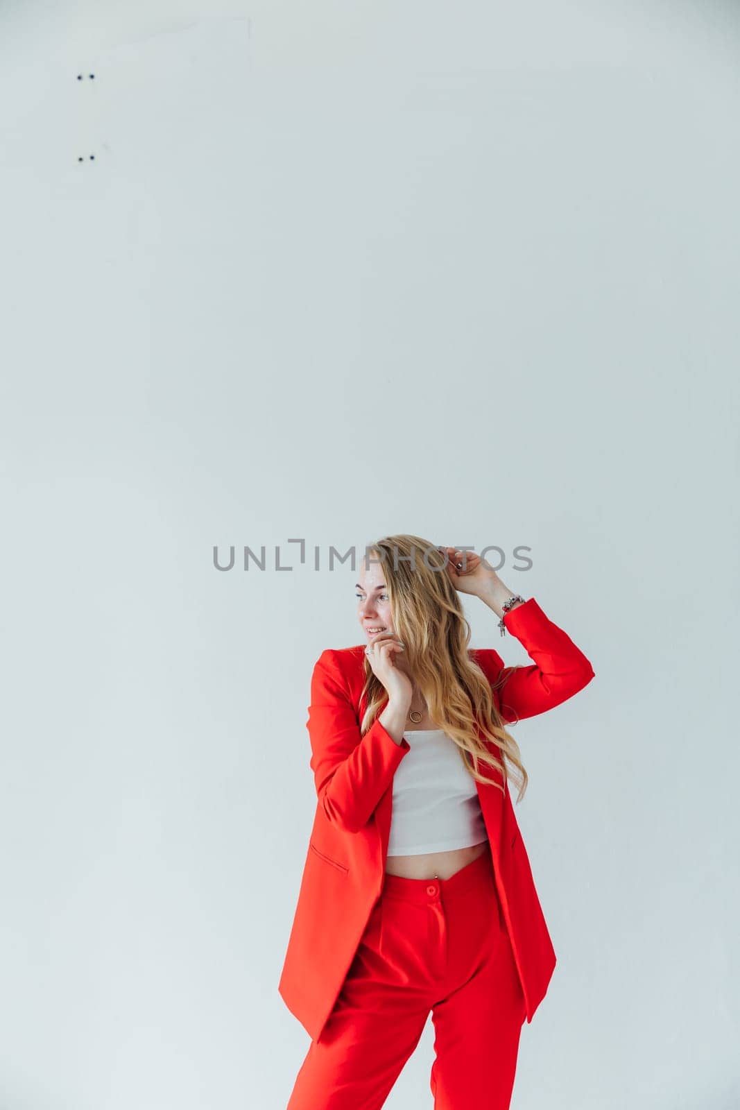 Beautiful fashionable blonde woman in red business suit by Simakov