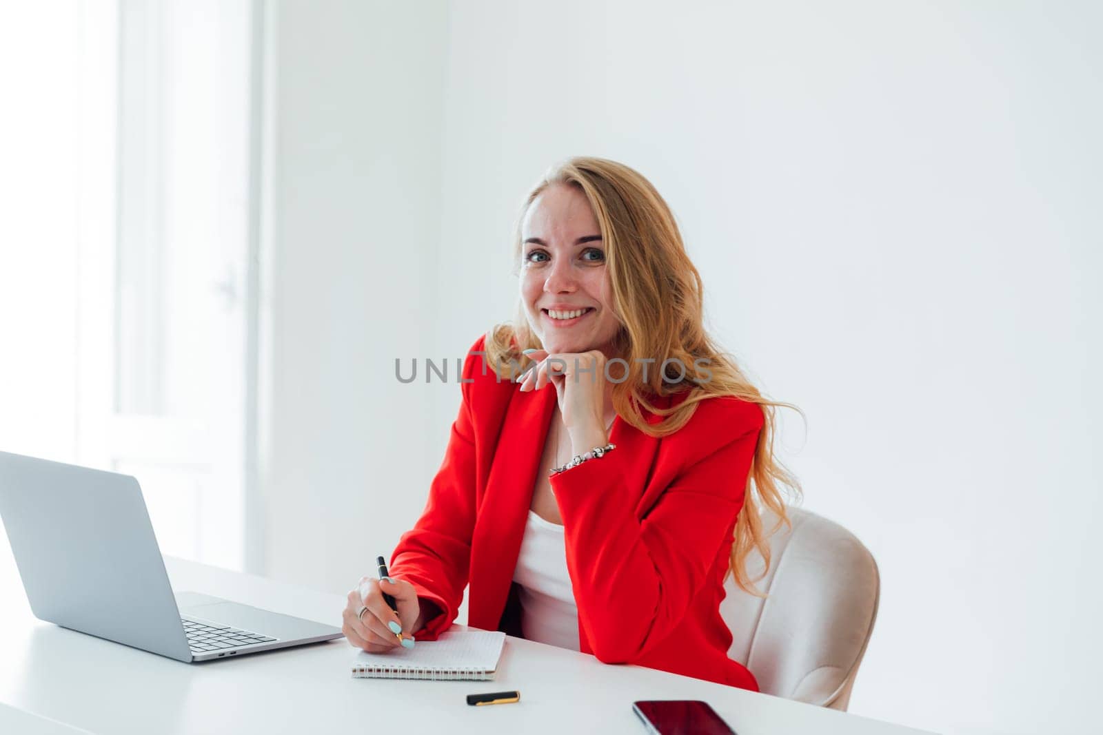 Woman in red business suit with laptop in office by Simakov