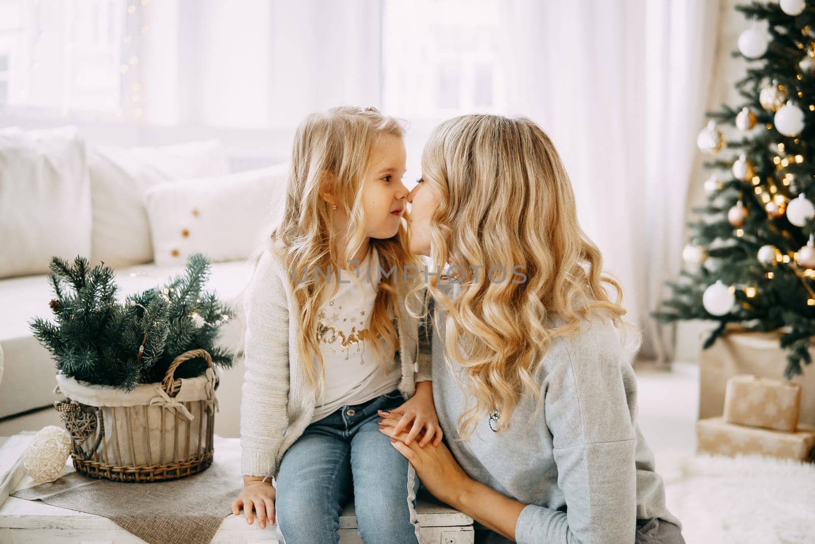 Happy family: mother and daughter. Family in a bright New Year's interior with a Christmas tree. by Annu1tochka