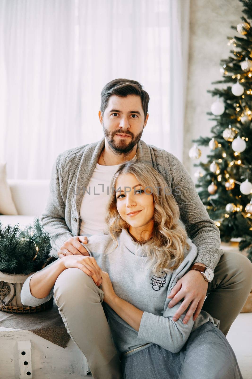 Happy family: mom, dad and pet. Family in a bright New Year's interior with a Christmas tree. by Annu1tochka