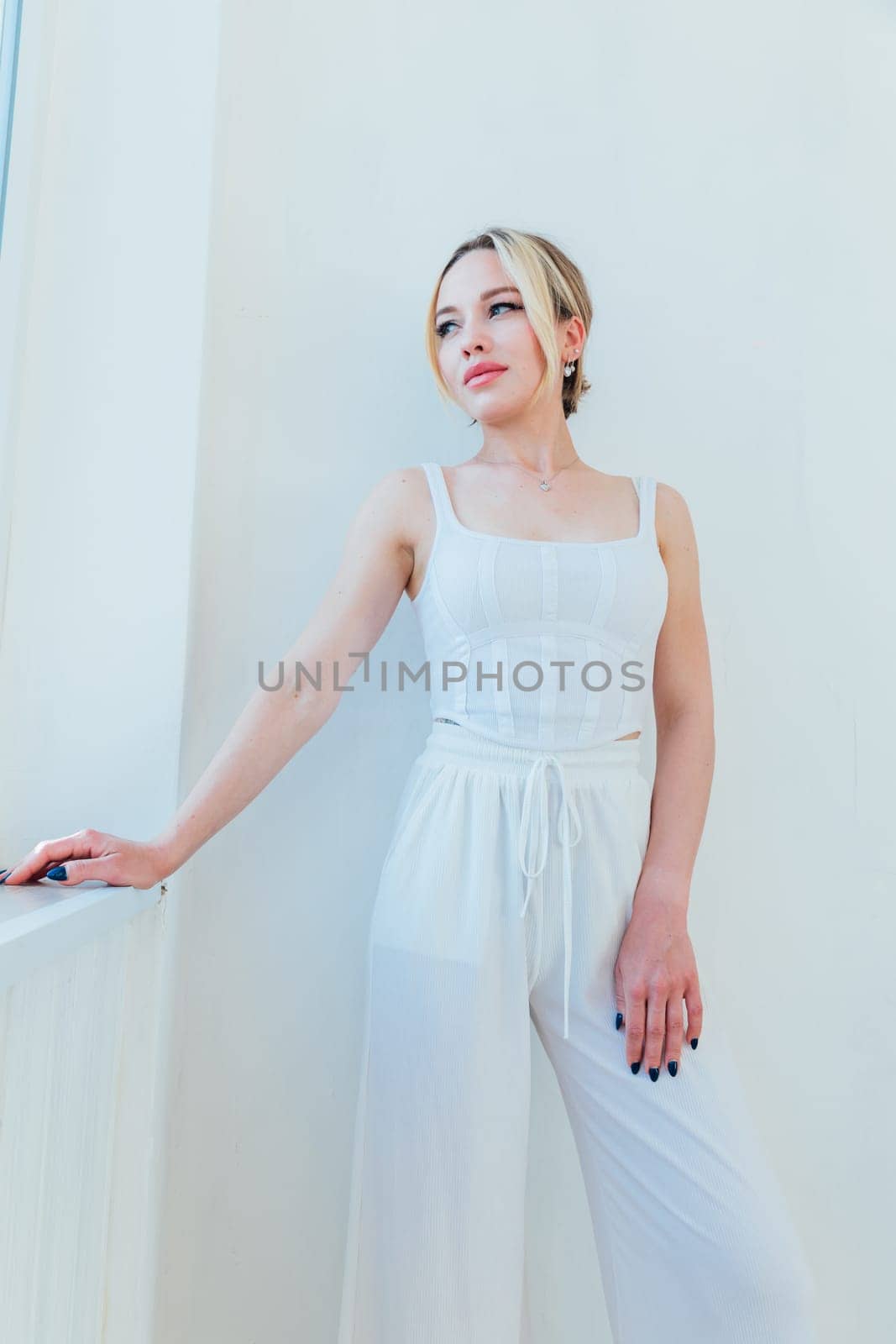 Beautiful slender blonde woman in white summer clothes