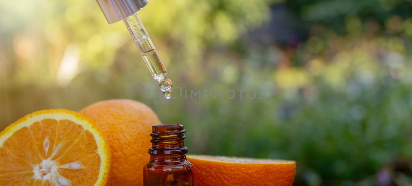 Essential extract of orange oil in a small bottle. Selective focus. by Anuta23