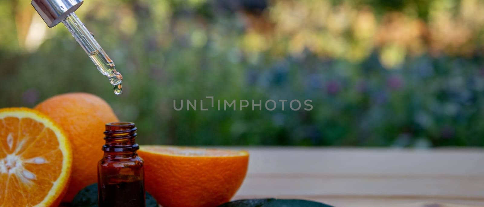 Essential extract of orange oil in a small bottle. Selective focus. by Anuta23