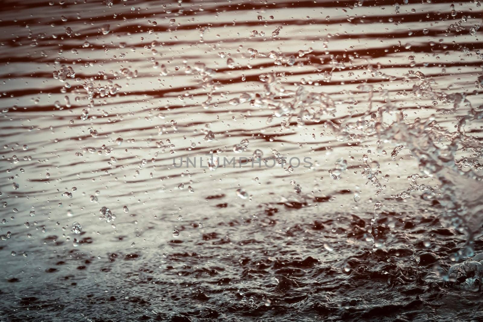 Beautiful background with splashes, drops of water in the river or ocean during the rain close up with nobody, wild nature water texture.