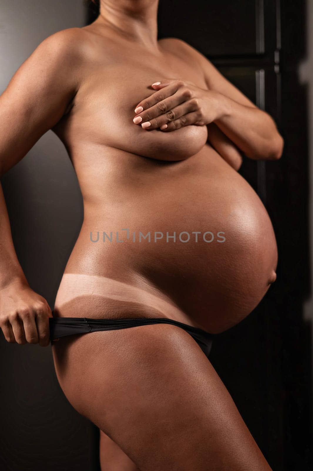 Pregnant woman pulls back her panties showing instant tan